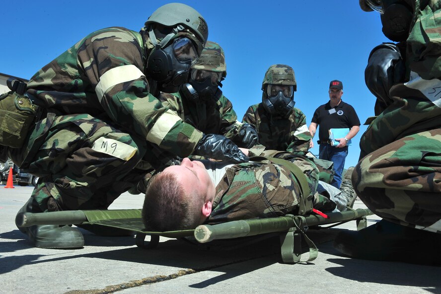 MINOT AIR FORCE BASE, N.D. -- Rodney Onstott, 5th Civil Engineer Squadron, deputy readiness & emergency flight chief, looks on as Airmen assist a wounded wingman during the Ability to Survive and Operate exercise here May 2.  The ATSO preparation exercise ensures that the Airman of Minot ready themselves for upcoming base wide inspections. (U.S. Air Force photo/ Senior Airman Jesse Lopez)