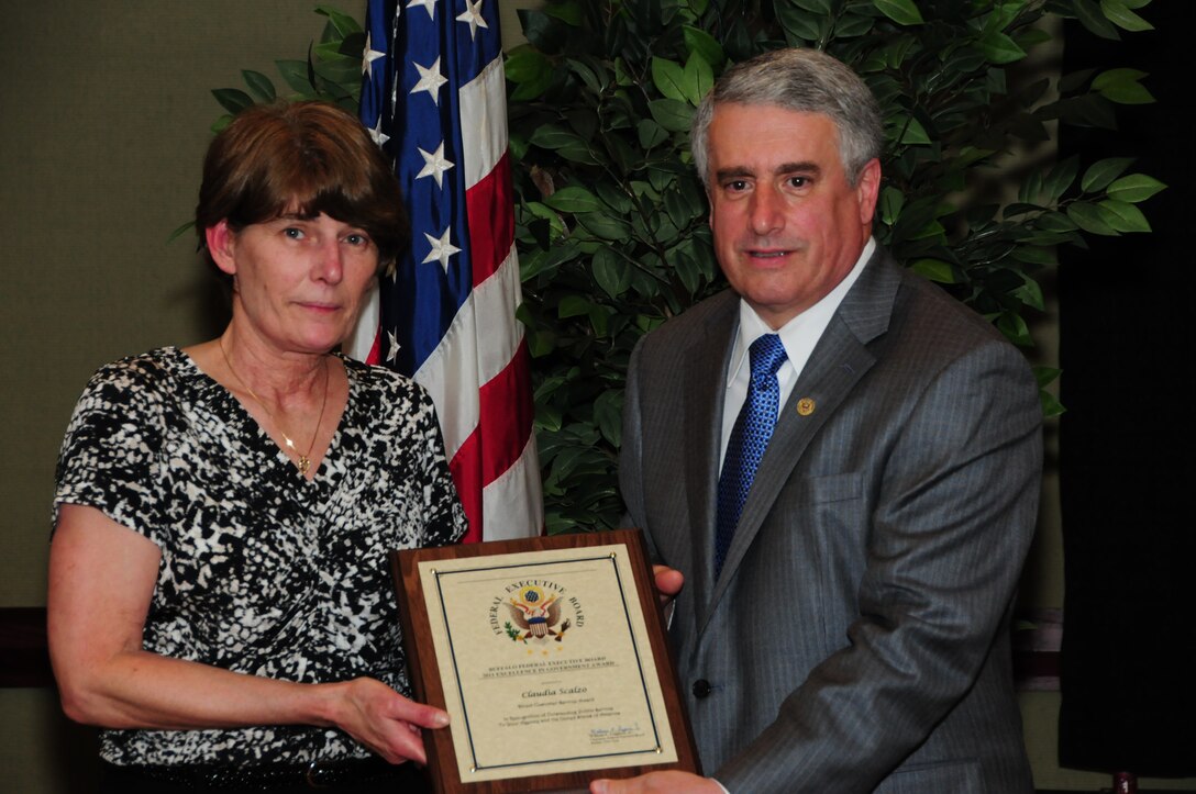 BUFFALO, N.Y.- Ms. Claudia Scalzo, lead travel technician, 914th Airlift Wing was presented with the Direct Customer Service Award from Mr. William E. Leggiero, Jr., Buffalo Federal Executive Board Chairman for her outstanding accomplishments and being responsible for the processing and auditing of travel vouchers for 1,200 military and 400 civilian personnel. The Excellence in Government Awards Ceremony was held at the Buffalo Convention Center.  The 914th Airlift Wing was among many  other federal agencies represented at the ceremony. The wing had seven members win in six different categories. (U.S. Air Force Reserve photo by Peter Borys)