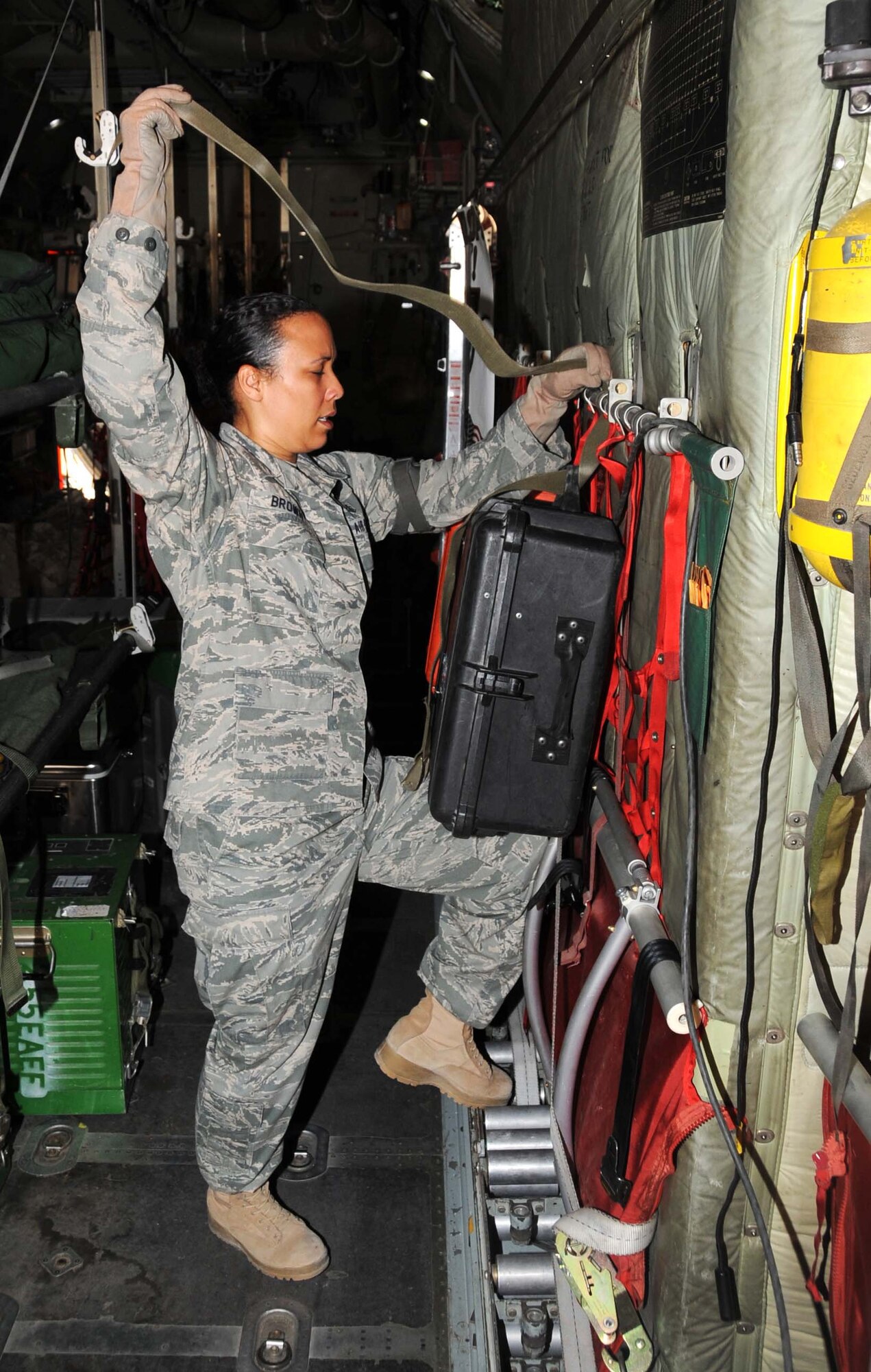 Master Sgt. Carie Brown from the 379 Expeditionary Aeromedical Evacuation Squadron ties down a strap in preperation for flight May 4 in Southwest Asia.  Sergeant Brown and other memebers make set up litters and other equipment prior to the crew's arrival. (U.S. Air Force photo/ Staff Sgt. Anthony Graham)