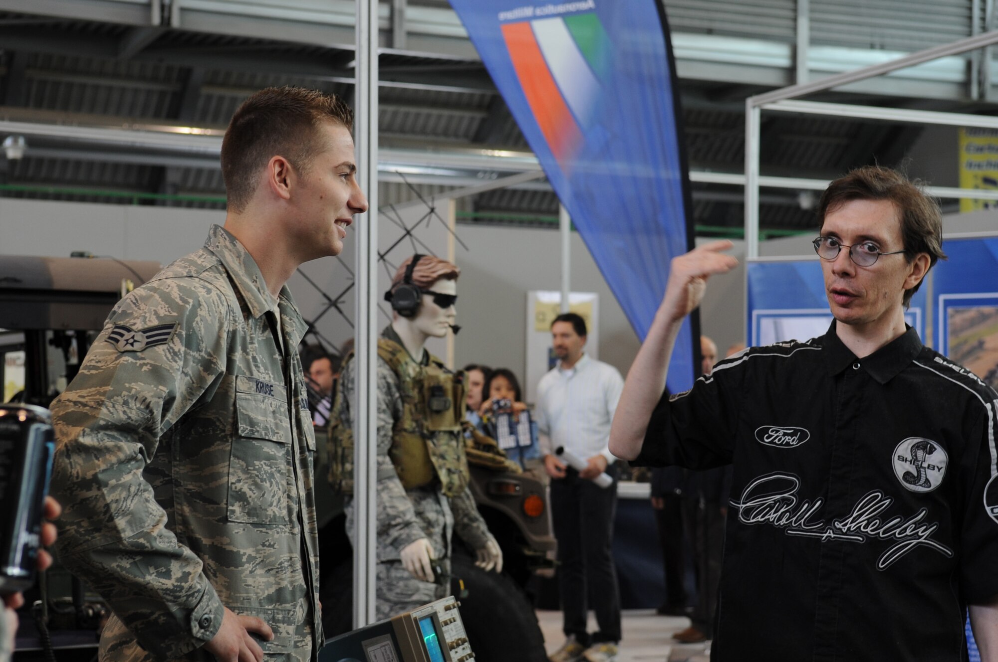 Senior Airman Kevin Kruse, 31st Communications Squadron ground radio systems journeyman, discusses radio frequencies with an Italian local national during the Pordenone Electronics Expo April 29.  Aviano Airmen participated to continue to develop positive communication between the two military cultures and the local community. (U.S. Air Force photo/ Staff Sgt. Nadine Y. Barclay)