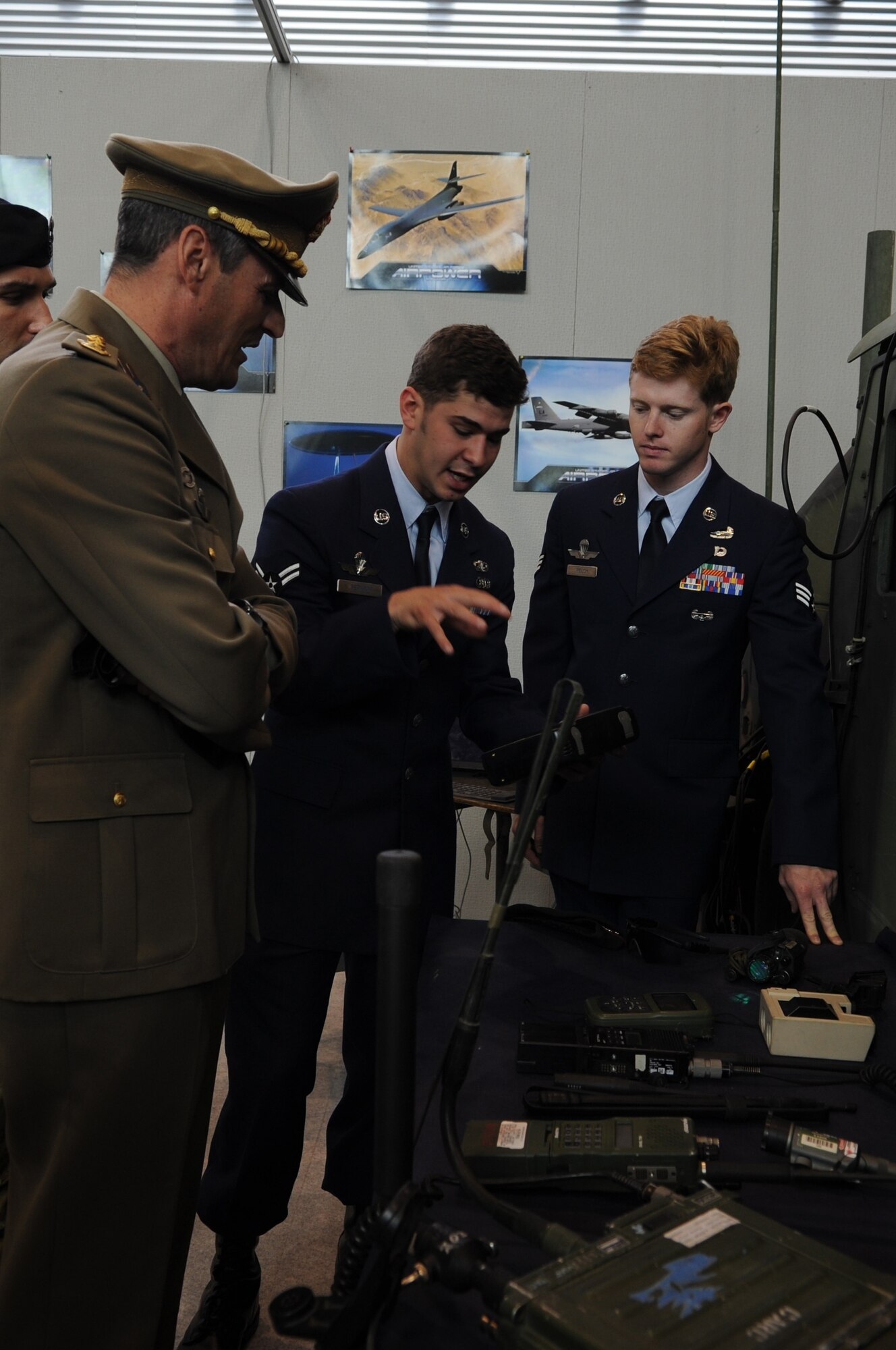 Airman 1st Class Jonathan Sepanik and Senior Airman Scott Welch, 8th Air Support Operations Squadron, explain the capabilities of handheld tactical communications equipment to an Italian Army Colonel during the Pordenone Electronics Expo April 29.  Aviano Airmen participated to continue to develop positive communication between the two military cultures and the local community. (U.S. Air Force photo/ Staff Sgt. Nadine Y. Barclay)
