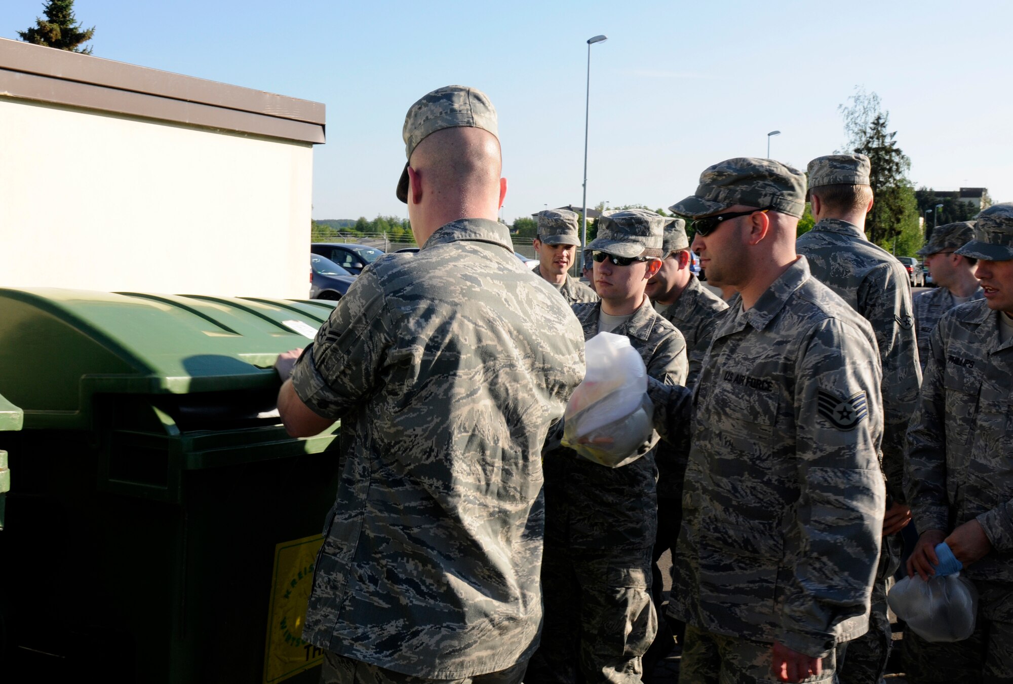 SPANGDAHLEM AIR BASE, Germany – Airmen from the 52nd Fighter Wing throw away trash during a base clean-up after the 2011 Spring Bazaar here May 2. The clean-up took place to prevent foreign object debris from getting on the flightline and taxiways and potentially damaging aircraft. (U.S. Air Force photo/Airman 1st Class Brittney Frees)
