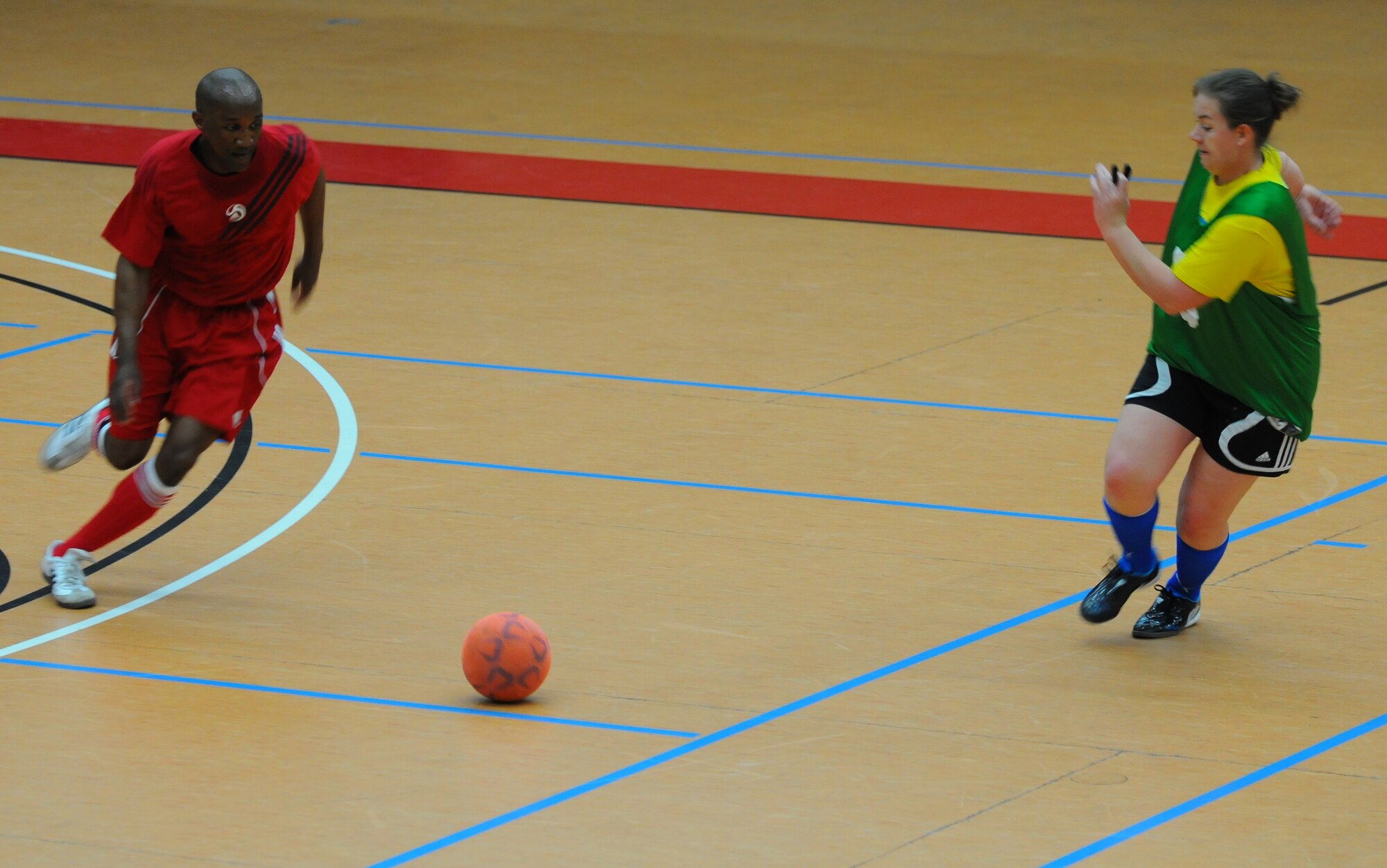 SPANGDAHLEM AIR BASE, Germany –Alfred Doby, left, 52nd Aerospace Medicine Squadron, and Tiffany Caramella, 52nd Civil Engineer Squadron, compete for possession of a soccer ball during an intramural soccer game at the Skelton Memorial Fitness Center here April 28. The 52nd CES defeated the 52nd Medical Group 6-2. (U.S. Air Force photo/Airman 1st Class Dillon Davis)
