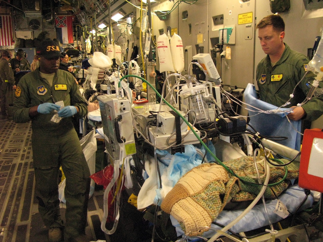 Air Force Staff Sgt. Napolean Gifford, left, respiratory technician for a critical care air transport team deployed to Ramstein Air Base, Germany, and Air Force 1st Lt. Brad Tiefel, the team’s intensive-care nurse, are part of an aeromedical evacuation capability that turns a C-17 Globemaster III into a flying intensive-care unit as they transport patients to increasingly advanced levels of care. DOD photo by Donna Miles 