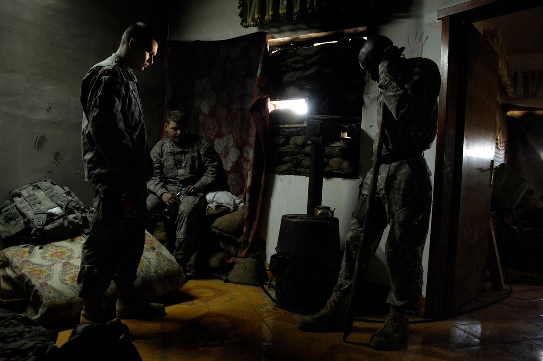 Army Spc. Chris Jankowski, Army Spc. Joshua Philbeck and Army Staff Sgt. Lawrence Washington take time to reflect on their departed friends during some down time in Buhriz, Iraq, Jan. 27, 2007. U.S. Air Force photo by Stacy Pearsall
