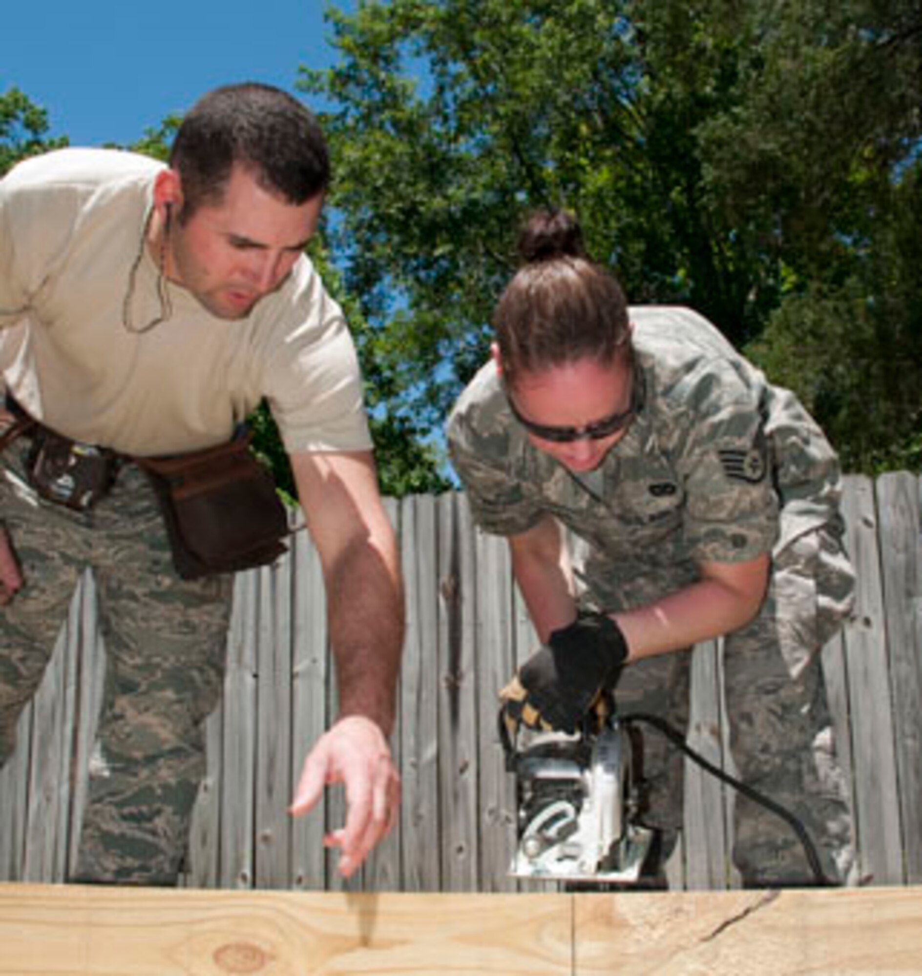 HAYNEVILLE, Ala. -- Staff Sgt. Abigail Olivares, a utilities specialist from the 176th Civil Engineer Squadron, learns to cut a structural beam May 4 under the guidance of Tech. Sgt. Mark Smith, also from the 176th CES,  for a patio covering at a clinic here. Thirty-five members of the 176th Wing arrived here May 1 for 12 days of training through the Innovative Readiness Program. This program allows Guard and Reserve members to get the training they need while at the same time delivering real-world results -- in this case, providing an array of health-care and structural services to a historically underserved area. Alaska Air National Guard photo by Capt. John Callahan.