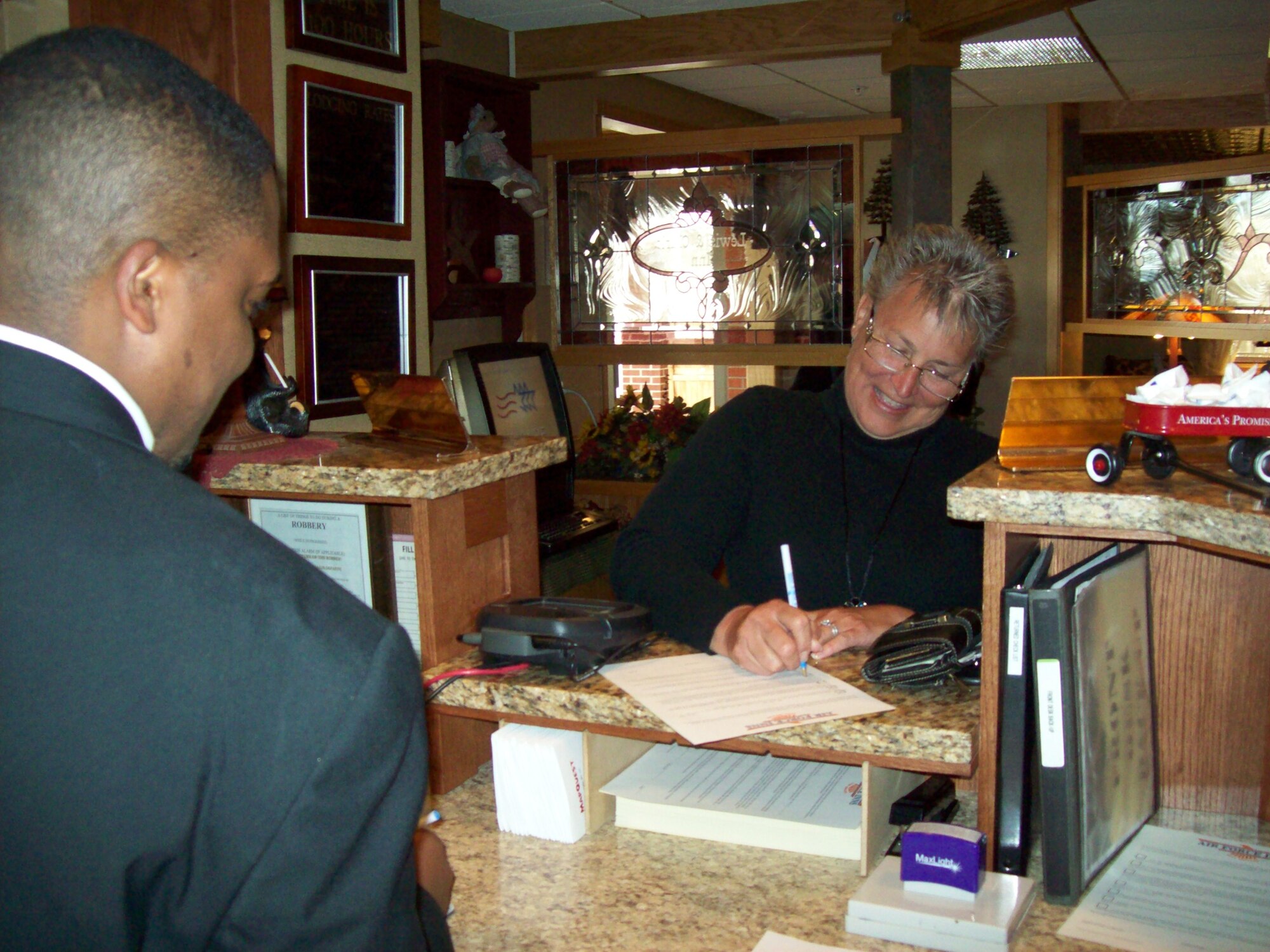 Antonio Hicks, an assistant general service manager at the Malmstrom Inns, checks in Air Force Inns Accreditation inspector Mynra Tiley on her recent visit to Malmstrom. (U.S. Air Force courtesy photo)