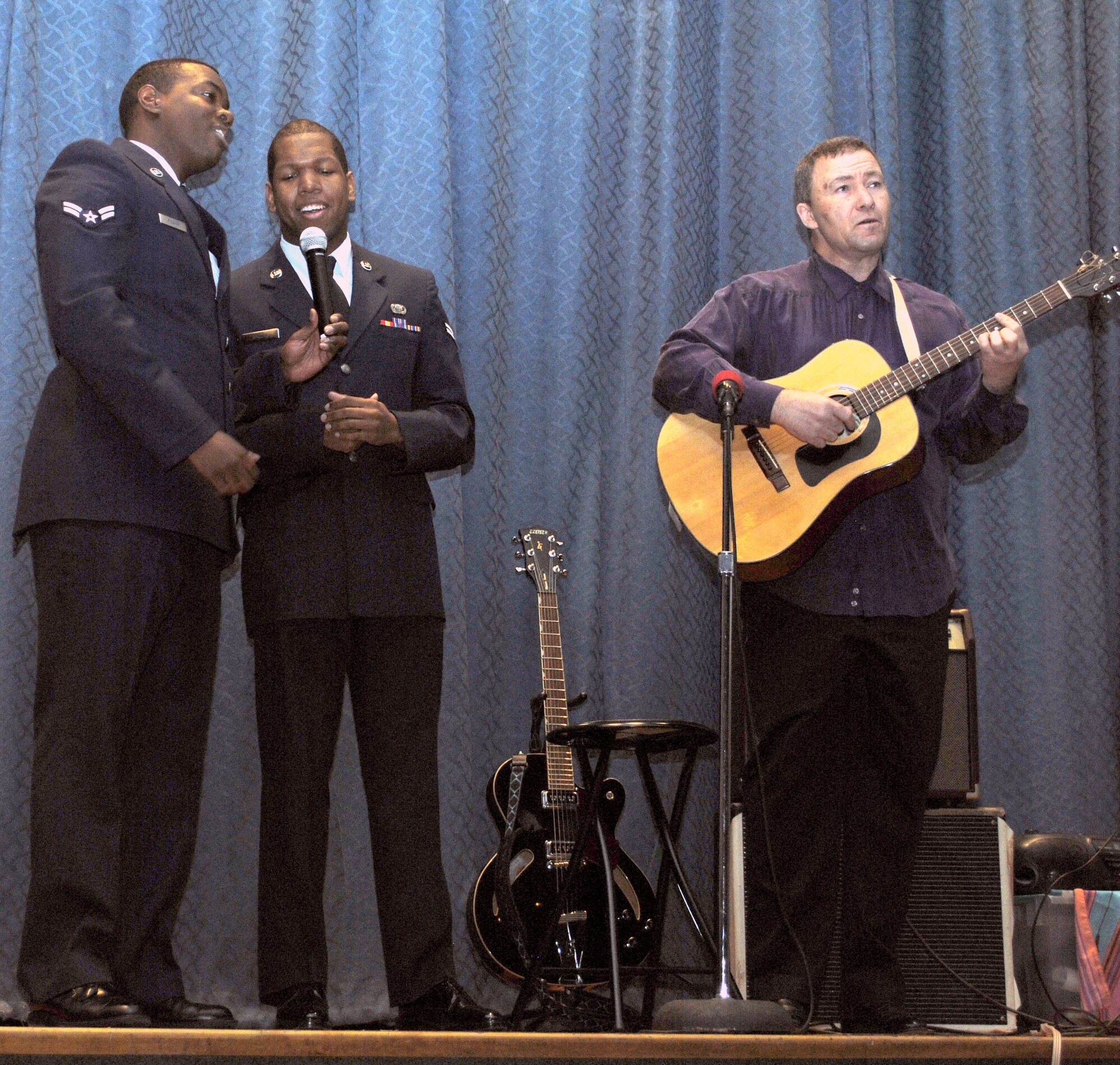 Airmen 1st Class Ryan McCray, 341st Medical Operations Squadron flight medicine technician, and Jonathan Greene, 341st Force Support Squadron customer service technician, sing "What the World Needs Now" to the guitar instrumentals of Brian Perry, a 341st Medical Operations Squadron PRP monitor.  Their song opened the Holocaust Commoration Cermony and was followed by speeches and readings dedicated to the members involved in the Holocaust.  (U.S. Air Force photo/Airman Cortney Hansen)