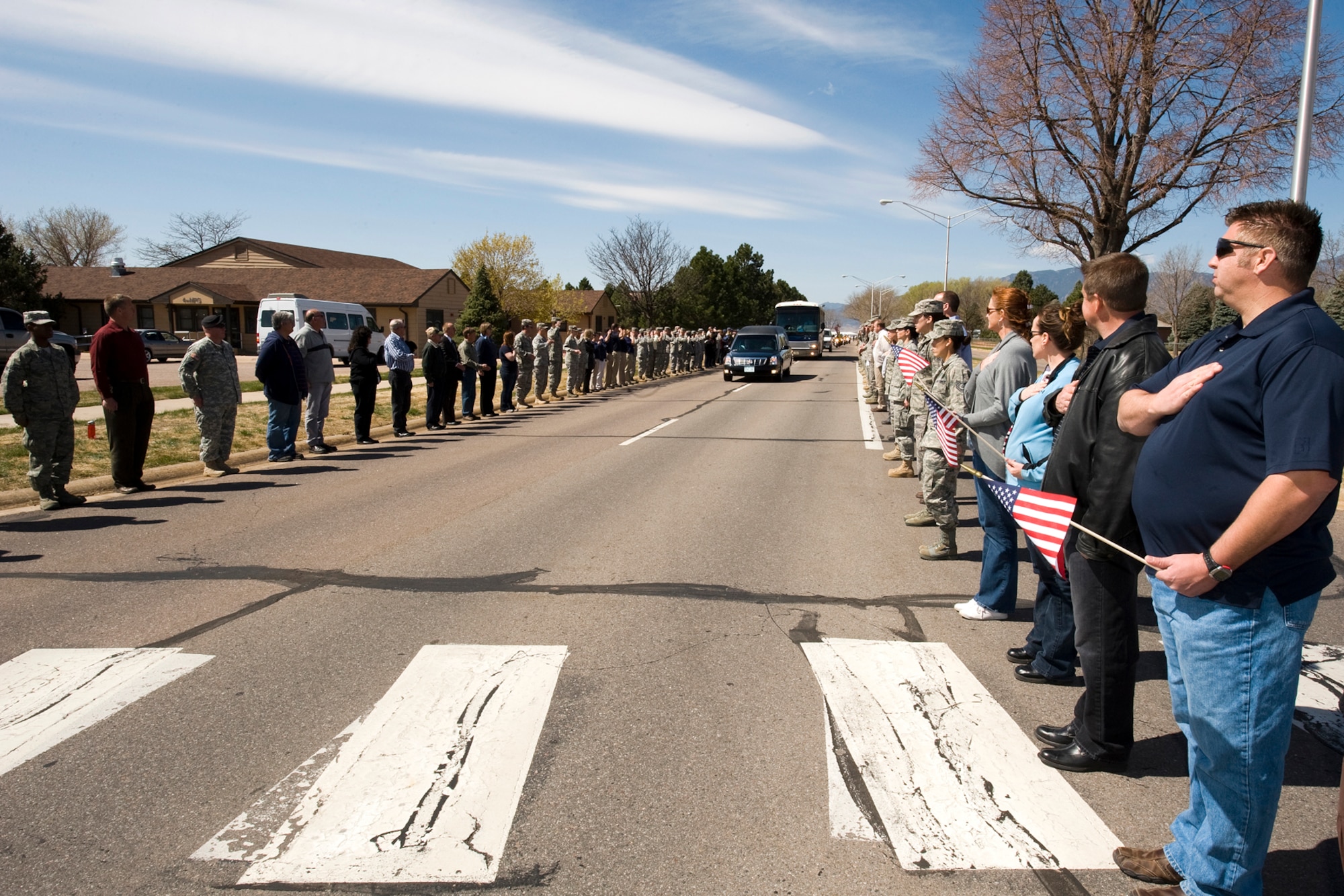 Servicemembers and civilians from Peterson Air Force Base line Peterson Boulevard May 4, 2011, for the return of Maj. Phil Ambard. Hundreds of Airmen lined the street from the flight line to the north gate to honor his service, commitment and dedication to the nation. Major Ambard, an instructor at the U.S. Air Force Academy, was killed in Afghanistan in April, and was interred May 5 at the USAFA cemetery. (U.S. Air Force photo/Rob Bussard)