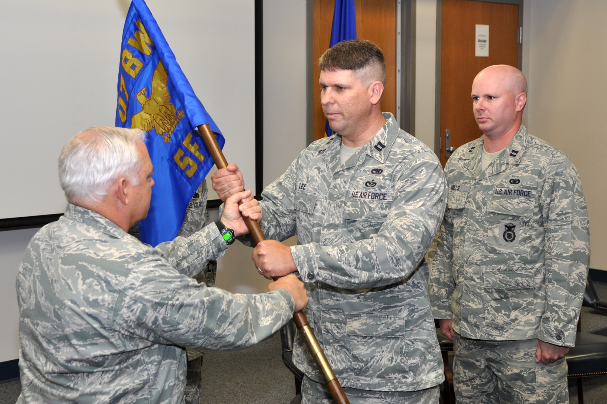 Col. Kevin Wolfe, commander, 307th Mission Support Group, 307th Bomb Wing, passes the guidon and command responsibilities for the 307th Security Forces Squadron to Capt. Mark Lee, during a change of command ceremony, Saturday, April 30, 2011, at Barksdale Air Force Base, La.  Captain Lee took the reins of the 307th SFS from Capt. Jimmie Mills. (U.S. Air Force photo/Tech. Sgt. Jeff Walston)