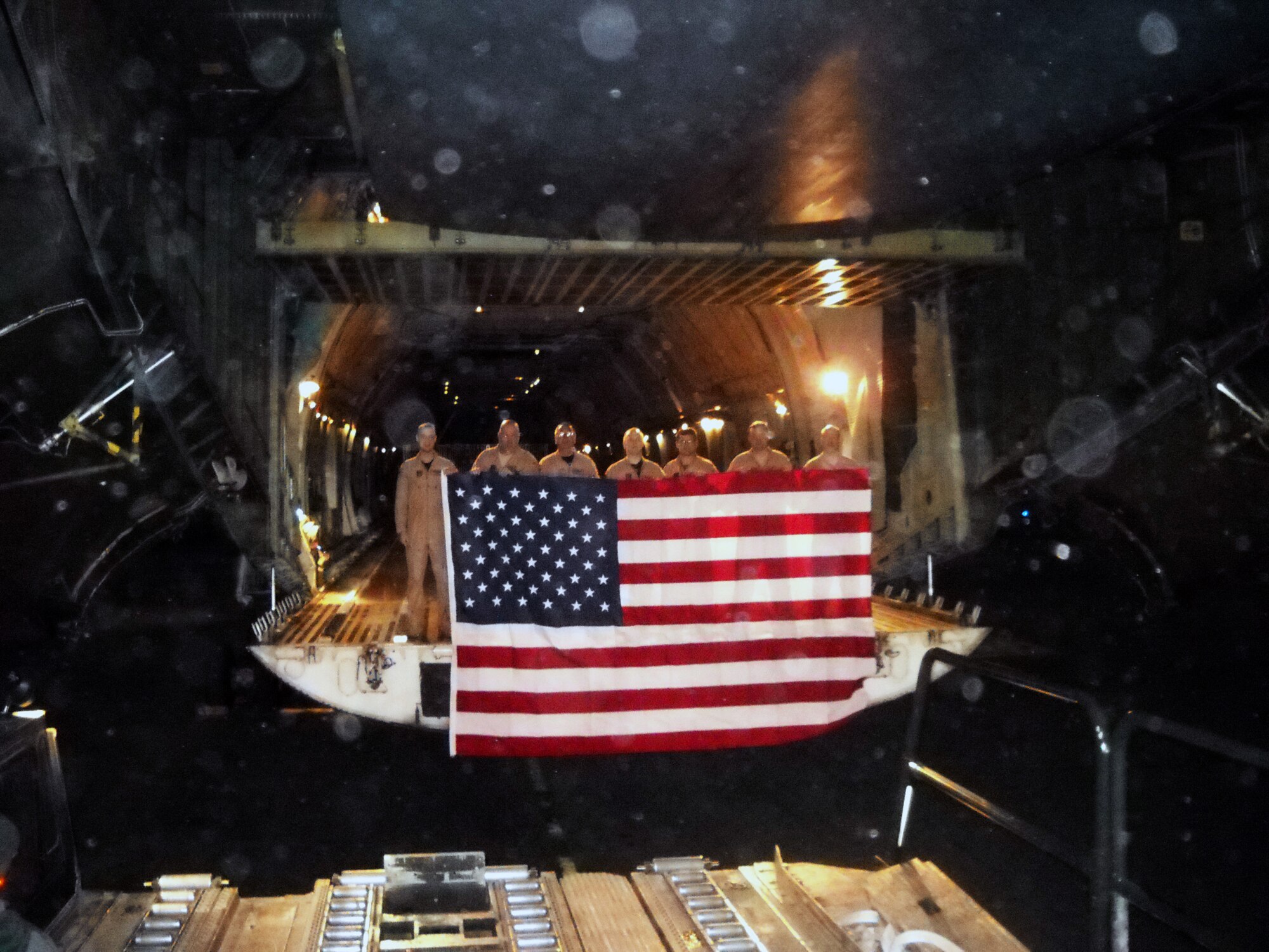 "Crew members from the 337th Airlift Squadron hold up an 8-foot by 12-foot
flag at a runway in Afghanistan.  In May, a representative donated the flag
to Plymouth, Mass., parade officials for use in their 2011 America's
Hometown Thanksgiving Celebration.
Last year, parade director Olly deMachado donated their U.S. flag to the Air
Force performance band, Tops in Blue, to bring with them to Afghanistan and
present to the troops during the group's Christmas tour. 
That left the Plymouth committee without a flag, so flight engineer Master
Sgt. Eric McGlynn and his wife purchased a replacement flag, which Sergeant
McGlynn brought downrange and later presented, along with a certificate of
authenticity, to Mr. deMachado."
