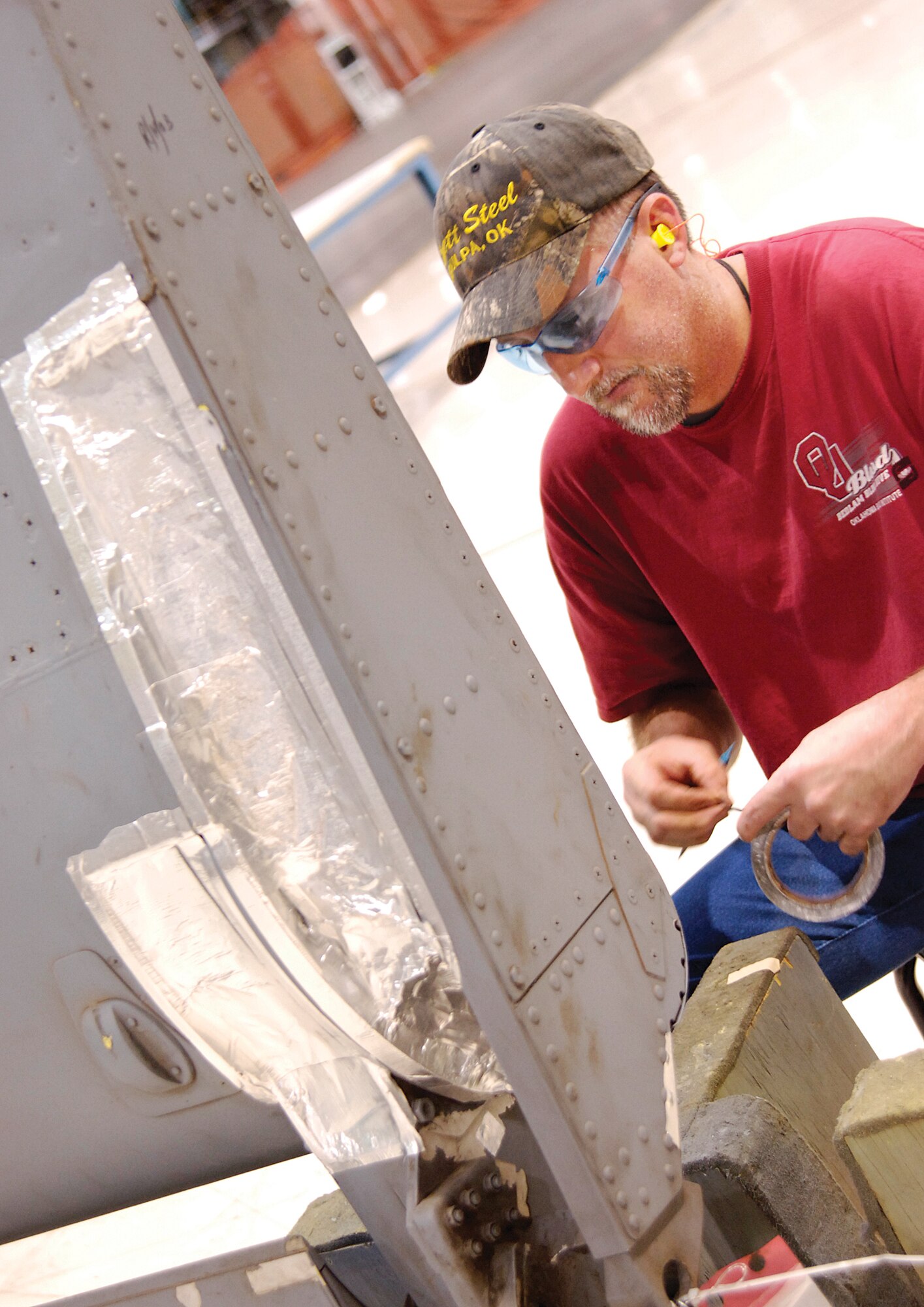 Using standardized procedures increased production in the Wash/Strip area of the 551st Commodities Maintenance Squadron, nearly tripling the amount of parts ready for customers.  Doug Applegate masks a KC-135 right-hand outboard flap preparing it for depainting and washing.  Masking was one of many processes standardized following a Rapid Improvement Event in the shop.  (Air Force photo by Margo Wright)
