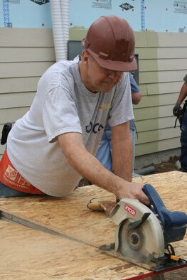 Chaplain (Lt. Col.) Bob Wood, Air Force Personnel Center assignments directorate, operates the circular saw during the April 30 Habitat for Humanity volunteer project.