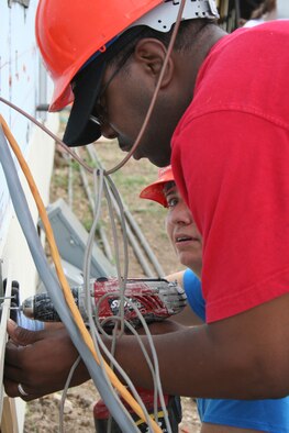 Tech. Sgt. Lasabra Johnson (front) and Col. Lorrie Cappellino, Air Force Personnel Center assignments directorate, attach work around utility lines to attach siding during the April 30 Habitat for Humanity volunteer project.