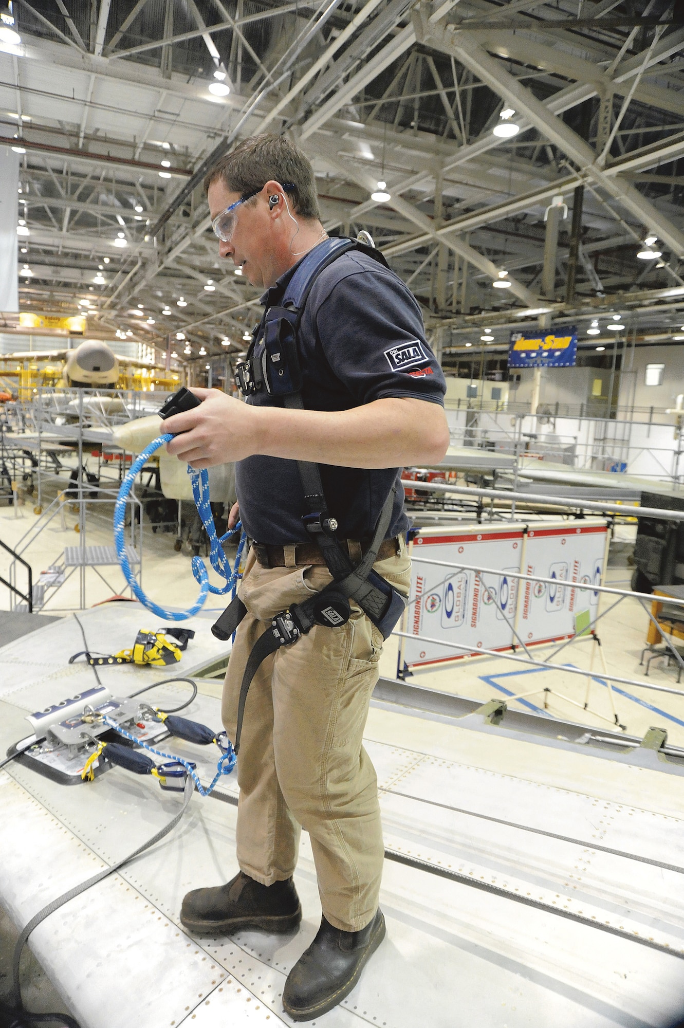 Will Bazela demonstrates the four-man vacuum anchor, which can be used for meeting the four foot fall protection standard. U. S. Air Force photo by Ray Crayton