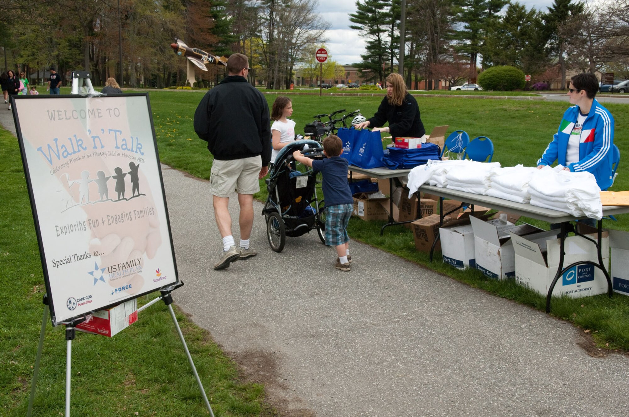 HANSCOM AIR FORCE BASE, Mass. – A family picks up T-shirts and bags at the beginning at Walk n Talk at Castle Park April 30. Hanscom families were invited to walk around Castle Park, learn about base and community services and talk about important family issues. (U.S. Air Force photo by Rick Berry)