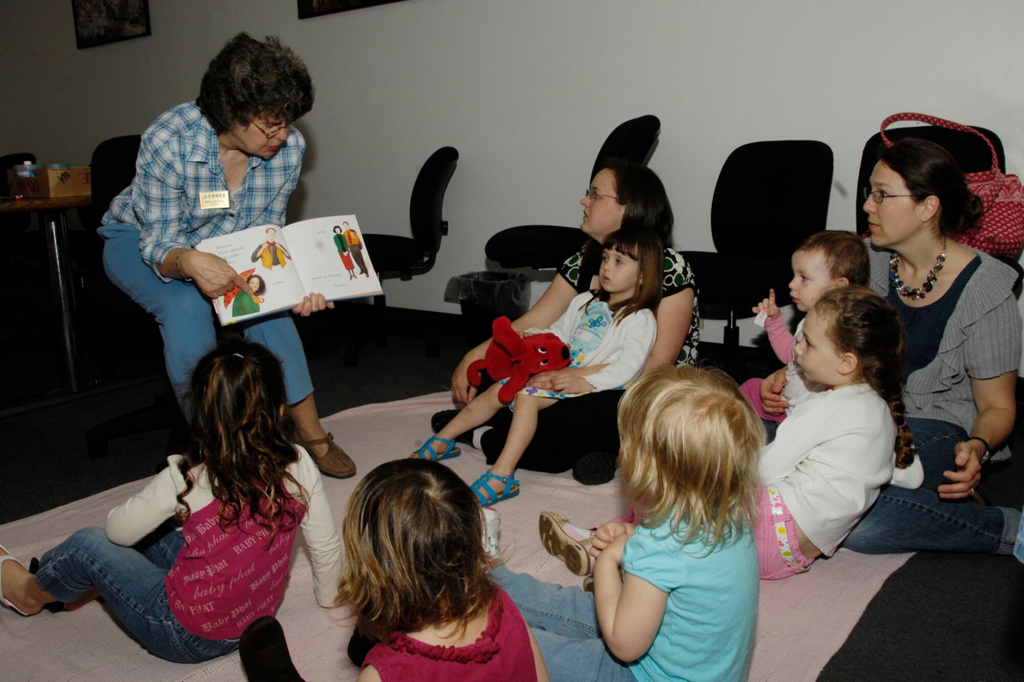 HANSCOM AIR FORCE BASE, Mass. – Librarian Pam Medolo (left) reads “The Grouchy Ladybug” by Eric Carle to children and parents during Storytime at the Hanscom Library April 27. The library hosts storytimes for preschoolers several times a month. (U.S. Air Force photo by Linda LaBonte Britt)