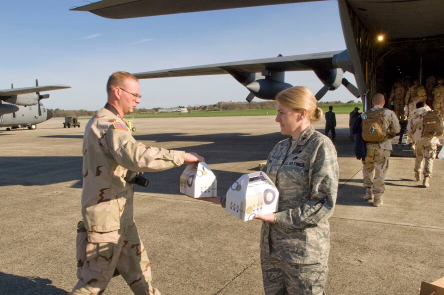 HANSCOM AIR FORCE BASE, Mass. - Members of the U.S. Coast Guard Maritime Safety and Security Team (MSST) pick up their box lunches from Maj. Jennifer Luoma (right), 66th Logistics Squadron, before deploying from Hanscom to Cuba. The Boston-based maritime anti-terrorism unit deployed May 2 in support of Operation Enduring Freedom. (U.S. Air Force photo by Mark Wyatt)