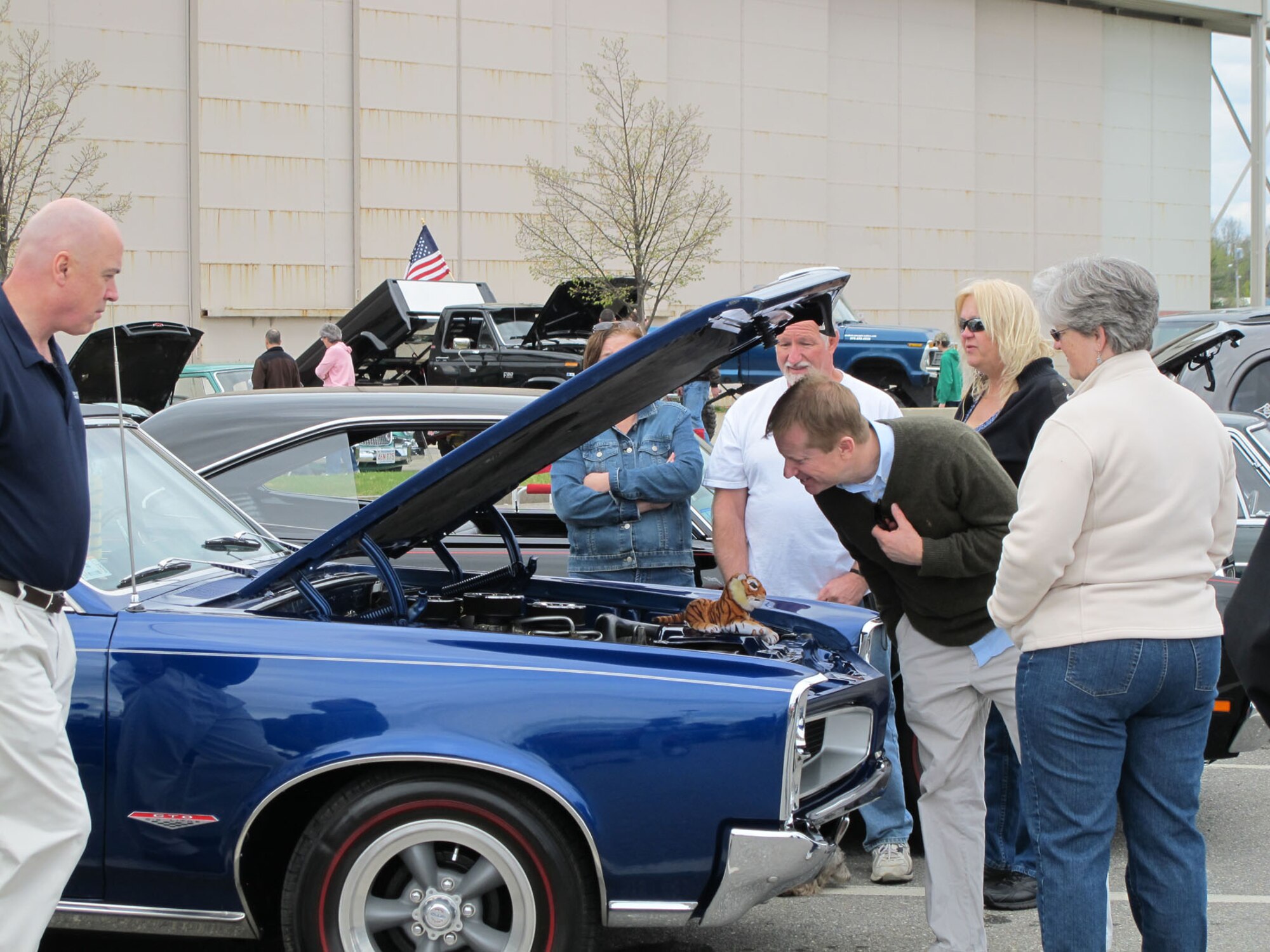 HANSCOM AIR FORCE BASE, Mass. – Attendees take a look under the hood of some classic cars during the “Cars are the Stars” car show in the Commissary and BX parking lot April 30. The 66th Force Support Squadron’s community programs office sponsored the car show in conjunction with a case lot sale at the Commissary and fitness display at the Exchange. The X-Band also provided entertainment. (Courtesy photo)