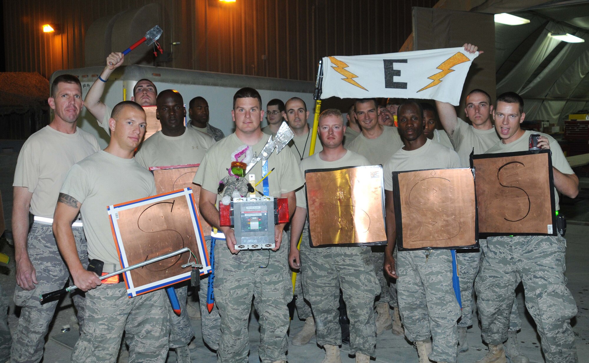 Airmen from the 379 Expeditionary Civil Engineer Squadron pose with their center piece during the Civil Engineer Combat Dining In May 4 in Southwest Asia. The center pieces were made by each flight and showcased at the event.  (U.S. Air Force photo/ Staff Sgt. Anthony Graham)