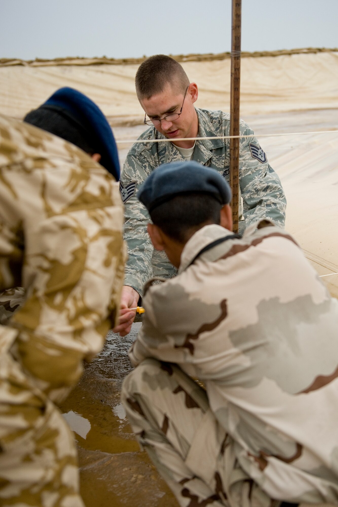 ALI AIR BASE, Iraq -- Staff Sgt Ryan Schaan, 407th Expeditionary Support Squadron petroleum, oils, and lubricants flight fuels supervisor, shows Iraqi servicemembers how to calculate an estimate of how much fuel is in a fuel bag April 22. The POL flight taught the Iraqis how to properly maintain their fuel area in order to prevent and minimize fuel spills. Sergeant Schaan is deployed from Nellis Air Force Base, Nev., and is a native of Grenora, N.D. (U.S. Air Force photo by Staff Sgt. Levi Riendeau)
