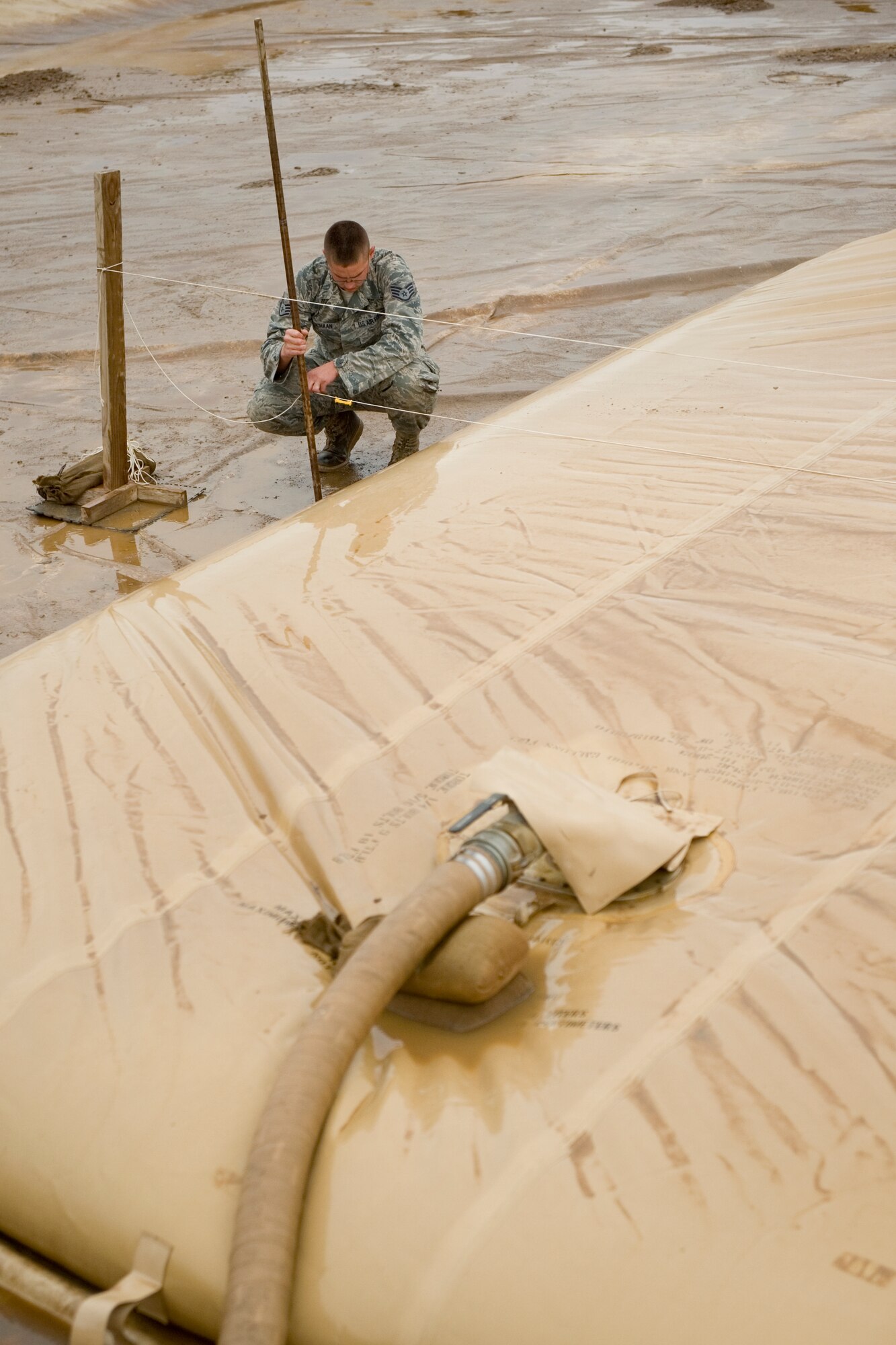 ALI AIR BASE, Iraq -- Staff Sgt Ryan Schaan, 407th Expeditionary Support Squadron petroleum, oils, and lubricants flight fuels supervisor, uses a measuring stick to calculate an estimate of how much fuel is in a fuel bag April 22. The POL flight taught the Iraqis how to properly maintain their fuel area in order to prevent and minimize fuel spills. Sergeant Schaan is deployed from Nellis Air Force Base, Nev., and is a native of Grenora, N.D. (U.S. Air Force photo by Staff Sgt. Levi Riendeau)
