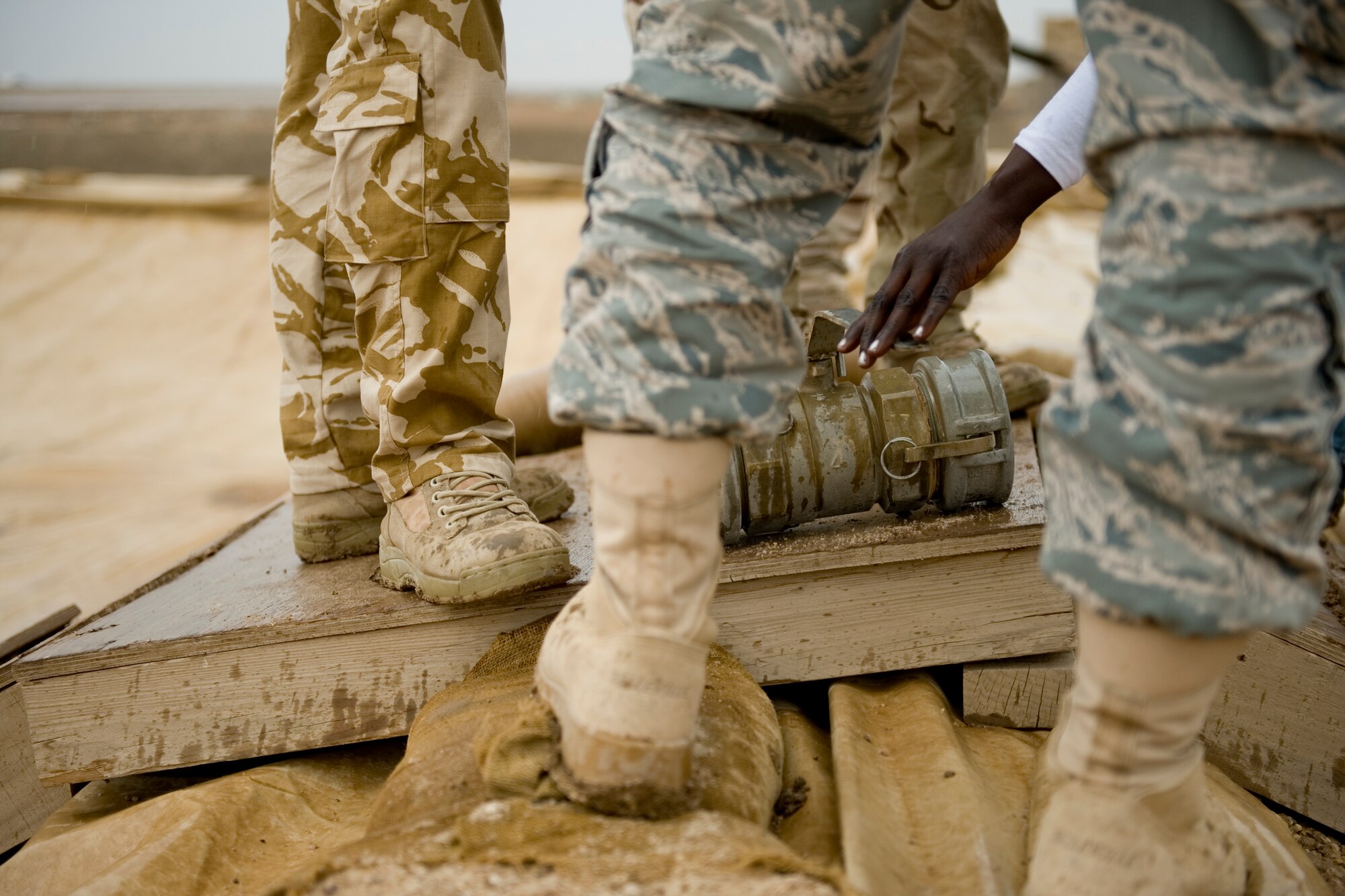 ALI AIR BASE, Iraq -- Members with the 321st Expeditionary Mission Support Advisory Group base transition team speak with Iraqis about a fuel hose connector April 22. U.S. Airmen taught Iraqi servicemembers how to properly maintain their fuel area in order to prevent and minimize fuel spills. (U.S. Air Force photo by Staff Sgt. Levi Riendeau)
