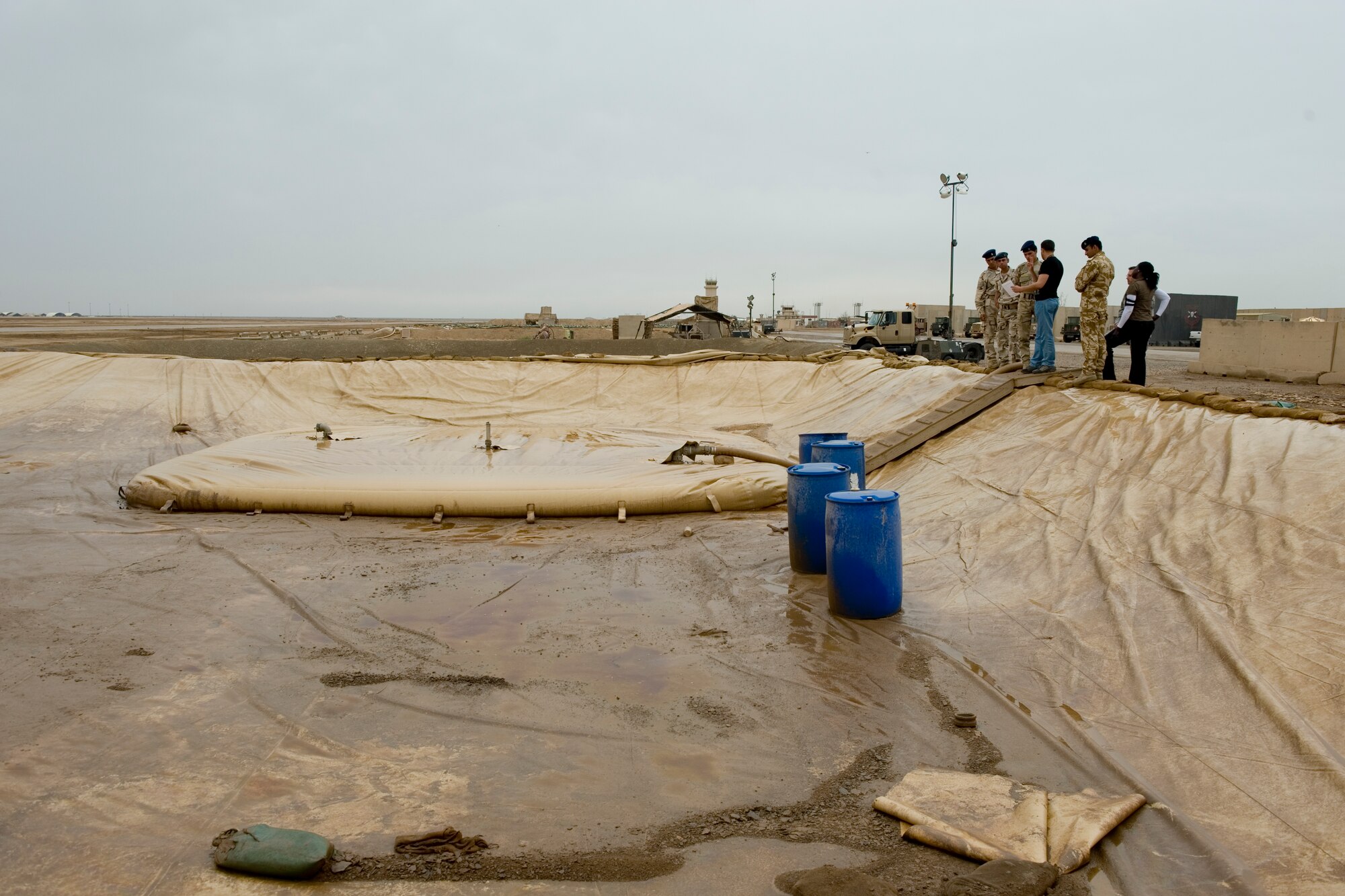 ALI AIR BASE, Iraq -- Members of the 407th Expeditionary Support Squadron petroleum, oils and lubricants flight view a fuel storage area with Iraqi military members April 22. The POL flight taught the Iraqis how to properly maintain their fuel area in order to prevent and minimize fuel spills. (U.S. Air Force photo by Staff Sgt. Levi Riendeau)
