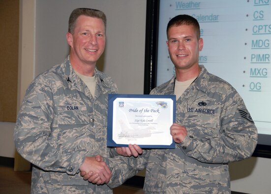 KUNSAN AIR BASE, Republic of Korea -- Col. John Dolan, 8th Fighter Wing commander, presents Staff Sgt. Kyle Lovell, 8th Aircraft Maintenance Squadron, with a Pride of the Pack award here May 5. (U.S. Air Force photo/Capt. Sheryll Klinkel)