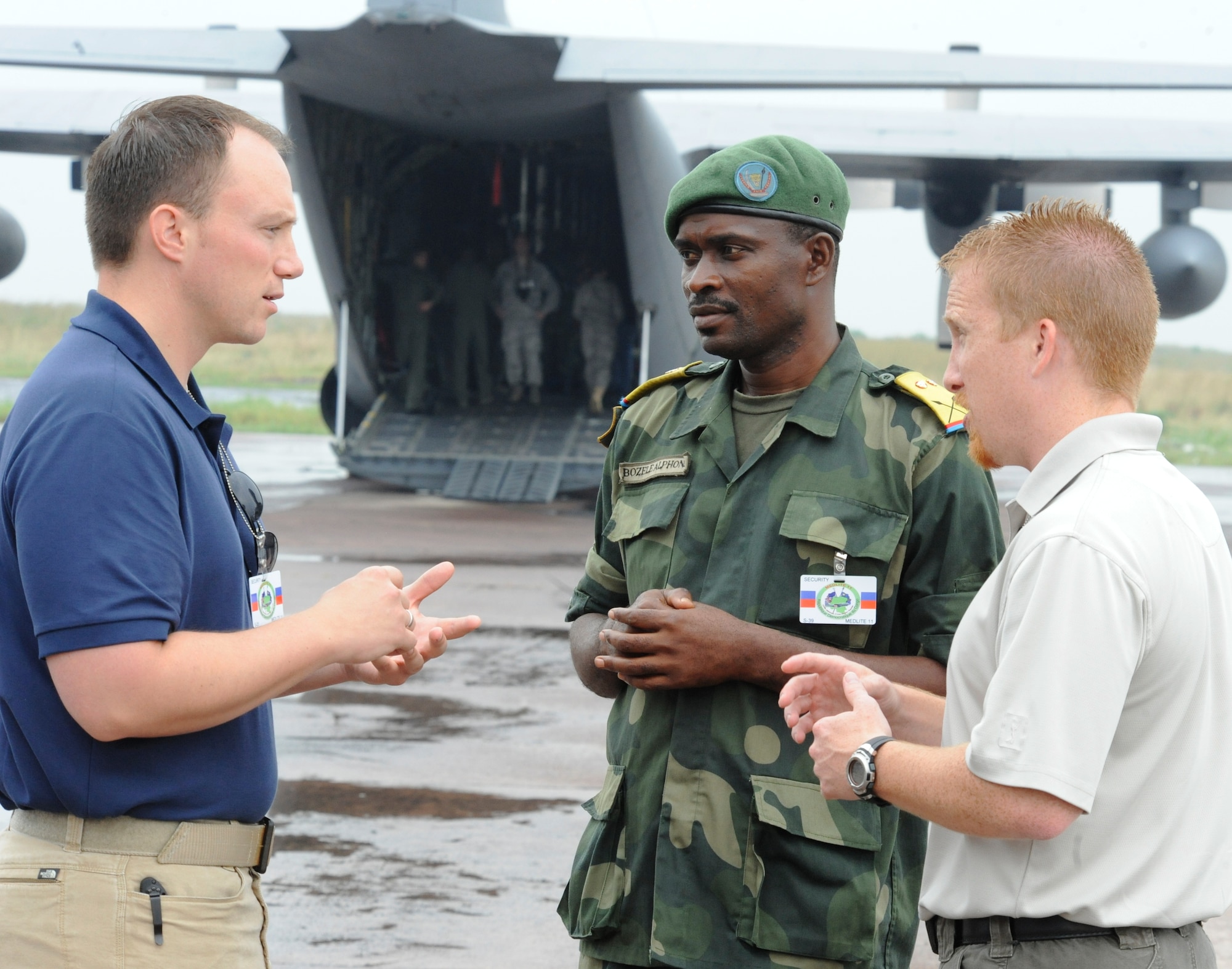 KINSHASA, Democratic Republic of the Congo -- U.S. Air Force Office of Special Investigation Agents Andrew Schofield (left) and Jess Bidlack (right) discuss security issues with their Congolese counterpart at the Kinshasa Airport, May 4, 2011. Special Agents Bidlack and Schofield have been supporting the MEDLITE 11 exercise for the last few months and have seen their work come to fruition during the last two weeks of execution. MEDLITE 11 is a joint medical exercise focused on aeromedical evacuation, to improve the readiness of U.S. Air Force and DRC personnel. (U.S. Air Force photo by Tech. Sgt. Todd Wivell)