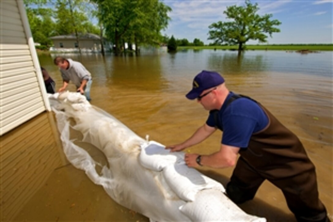 U.S. Coast Guard Senior Chief Darren Cliffe, right, helps build a sandbag wall around a home to try to save it from rising floodwaters in Brookport, Ill., May 4, 2011. Cliffe, a Reservist, is the senior leader of the Cincinnati-based Marine Security Detachment, which has deployed a disaster response team to the region.