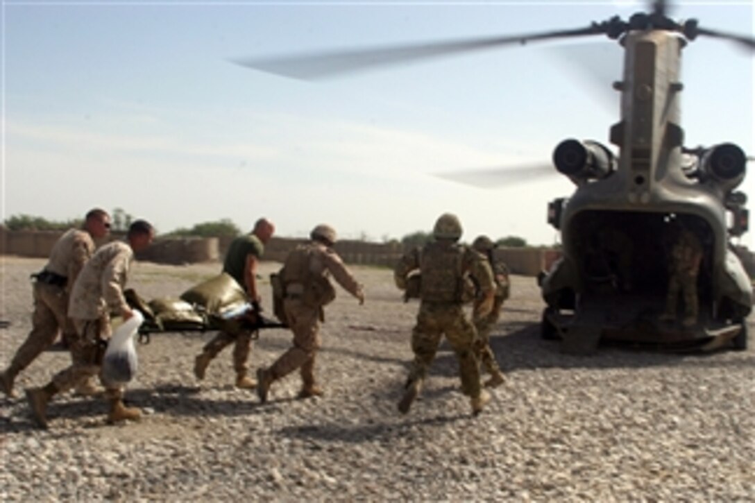 U.S. Marines and sailors with 1st Battalion, 5th Marines load an Afghan boy onto a CH-47 Chinook medical helicopter after he received emergency medical treatment at the battalionís aid station in Sangin, Afghanistan, on April 25, 2011.  The boy was seriously injured by an improvised explosive device and was transported to a medical treatment center for more extensive care.  