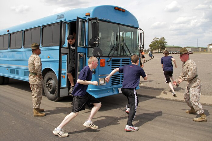 Drill instructors Sgt. Michael S. Bachicha and Sgt. Bryce E. Torrence motivate Recruiting Station Twin Cities mini boot camp participants from the Fargo, N.D., area to move faster as they exit the bus May 6. The Fargo office brought 34 individuals to attend the three-day boot camp. For additional imagery from the event, visit www.facebook.com/rstwincities.