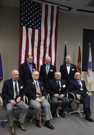 Medal of Honor recipients Don Jenkins, U. S. Army, Ken Stumpf, U. S. Army, Herald Fritz, U. S. Army, Ronald Rosser, U. S. Army, Leo Thorsness, U. S. Air Force, Sammy Davis, U. S. Army, and Hershel “Woody” Williams, U. S. Marine Corps, relax after touring the Caterpiller plant in Lafayette, Ind. Touring the plant was part of the events leading up to opening of the Medal of Honor Bridge.
