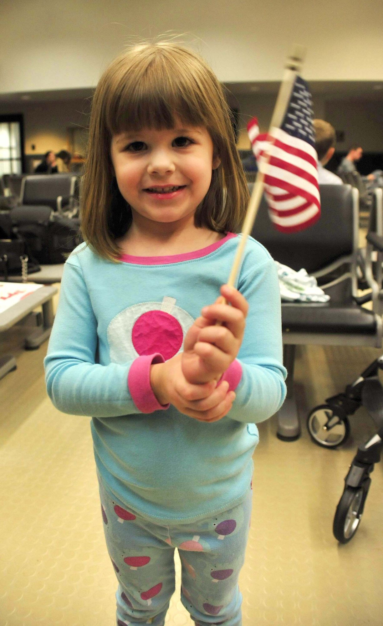 A girl waves an American flag as she waits for her father, a 7th Airlift Squadron pilot, to return from a 120-day deployment May 5 at Joint Base Lewis-McChord, Wash. (U.S. Air Force photo/Airman 1st Class Leah Young)