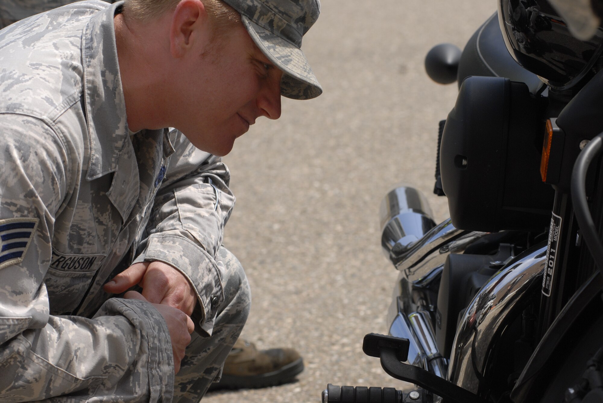 VANDENBERG AIR FORCE BASE, Calif. -- Performing a safety inspection, Staff Sgt. Michael Ferguson, a 30th Space Wing ground safety specialist, checks a motorcycle during the motorcycle safety briefing at the base theater Friday, May 6, 2011.  This annual safety briefing provides riders with insight and new information about regulations for riding their motorcycles safely.  (U.S. Air Force photo/Staff Sgt. Andrew Satran) 

 
 
 
 
