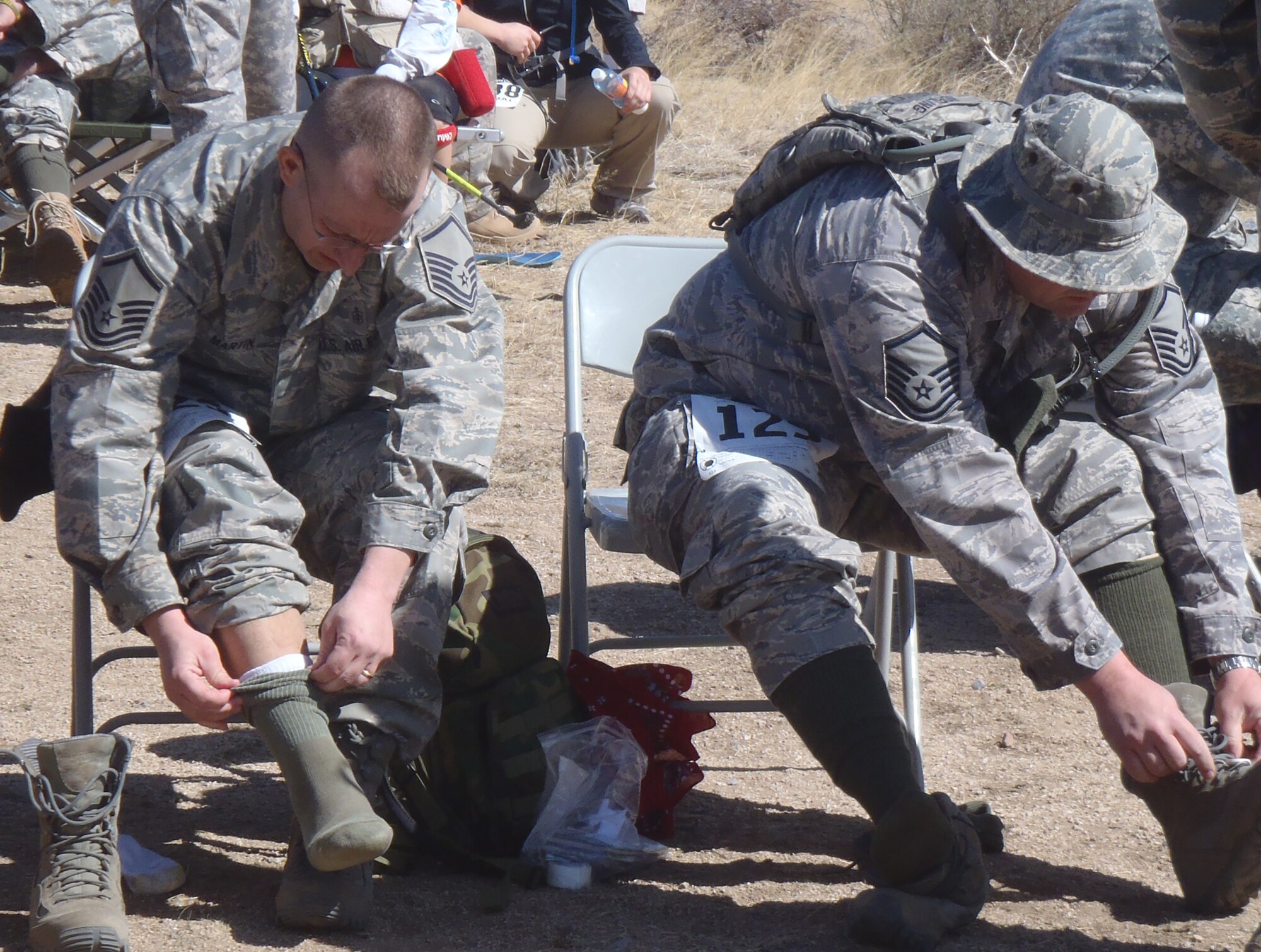 Master Sergeants Terry Martin (left) and Jeff Norling (right) change socks during the 26.2 mile Bataan Memorial Death March. (photo by Lt. Col. Bill Hefner)