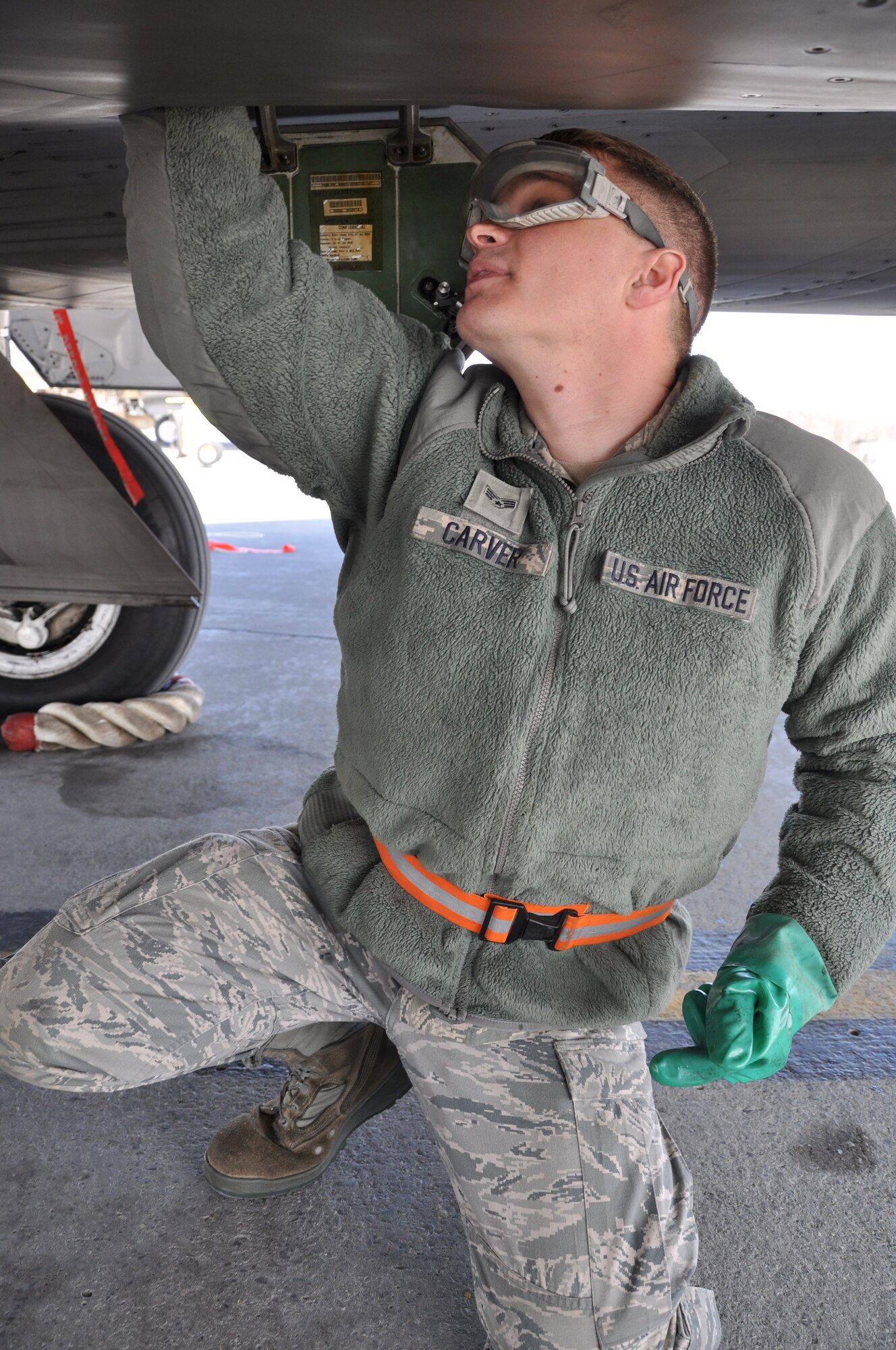 Senior Airman Shane Carver, collects oil samples from an F-22 upon its return from Alaska's Aviation Trade Show.