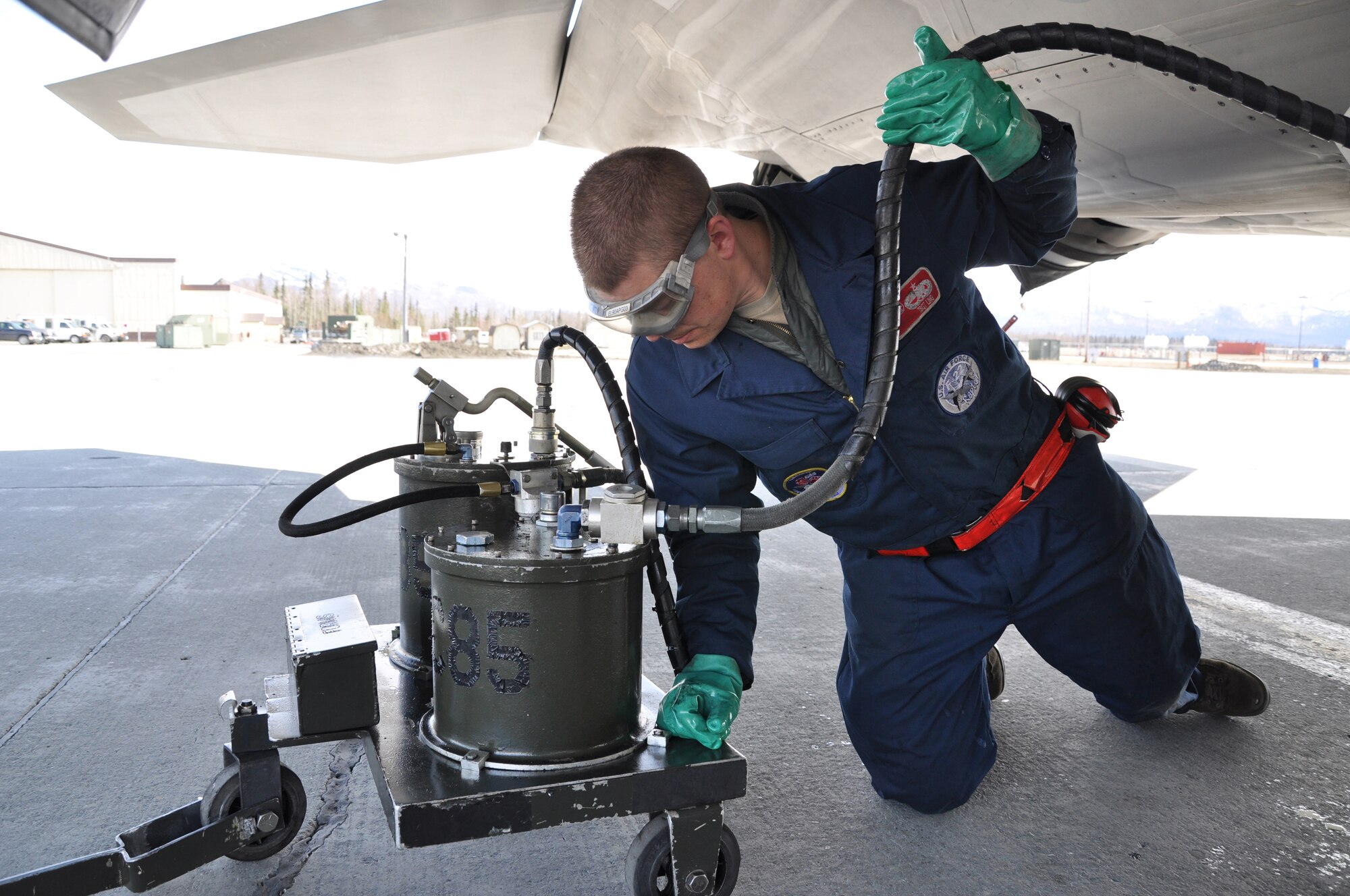 JOINT BASE ELMENDORF-RICHARDSON Alaska--Tech. Sgt. Mark Ling services the oil in an F-22 upon its return from Alaska's Aviation Trade Show held this past weekend at the Ted Stevens Airport.  Members of the Air Force Reserve's 477th Fighter Group took the jet to be a part of the show that included more than 275 vendors and was attended by more than 21,000 visitors. (Air Force Photo/Maj. Lisa Reaver)