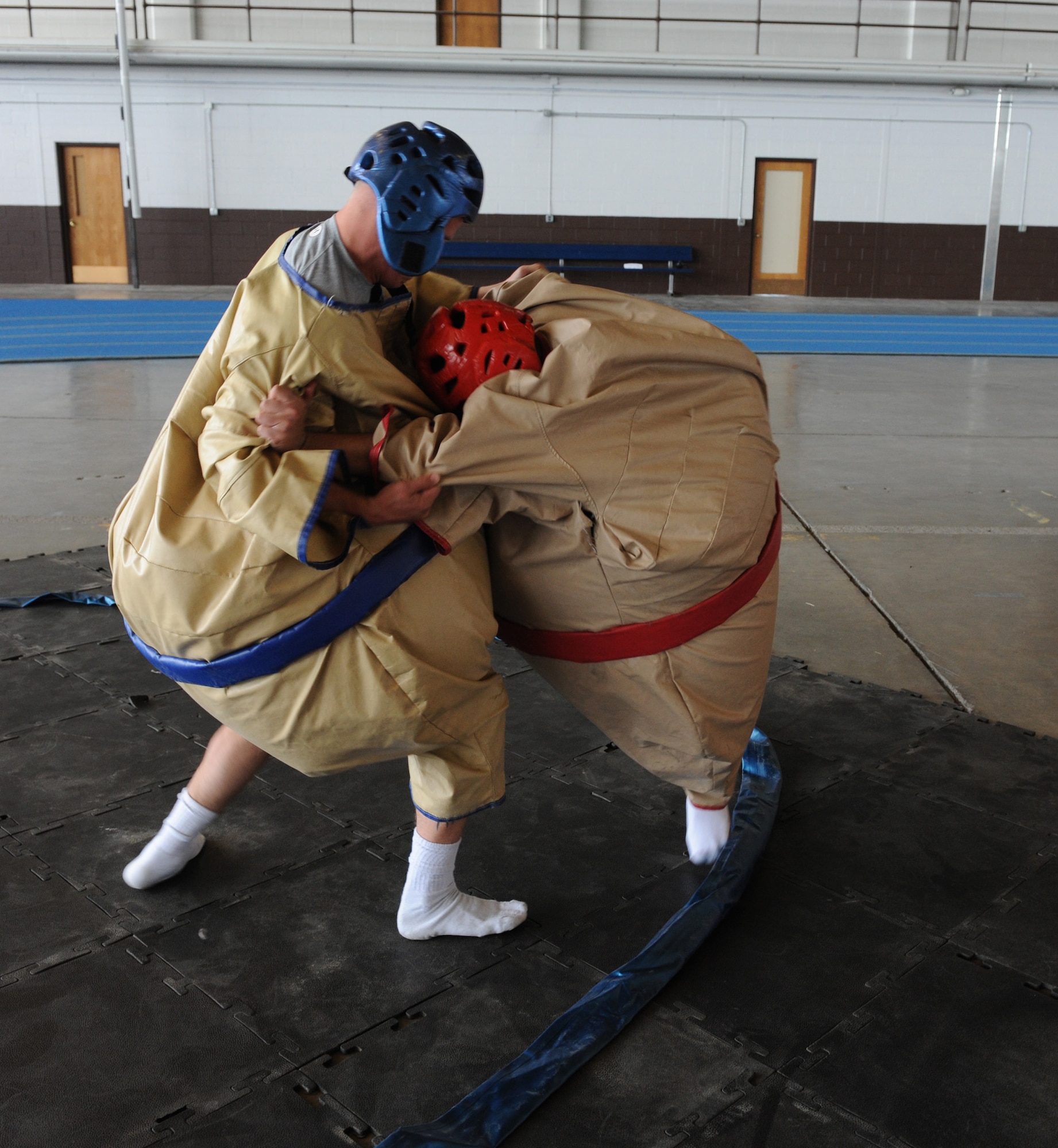 Airman 1st Class Patrick Garrett, 28th Civil Engineer Squadron electrician, and Senior Airman Justin Limos, Air Force Financial Services Center retirement and separation technician, participate in a sumo wrestling match during Multicultural Day at Ellsworth Air Force Base, S.D., May 3, 2011. The sumo wrestling was one of many sporting events conducted throughout the day.  (U.S. Air Force photo/Senior Airman Adam Grant)    