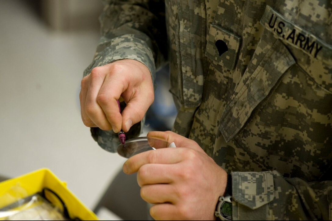 HAYNEVILLE, Ala. - U.S. Army Spc. Louis Reuter III, an optical lab specialist stationed at Fort Eustis, Va., identifies the left lens with a crayon, May, 2011. The lens will be used  for eyeglasses that will be given out for free. The eyeglasses were a part of the optometry services offered under the Innovative Readiness Training (IRT) mission. The IRT program allows for real-world training opportunities for military personnel while providing needed services to under-served communities in the United States. There were about 70 deployers from numerous military components and services in Hayneville for the IRT mission.  Alaska Air National Guard photo by Master Sgt. Shannon Oleson.