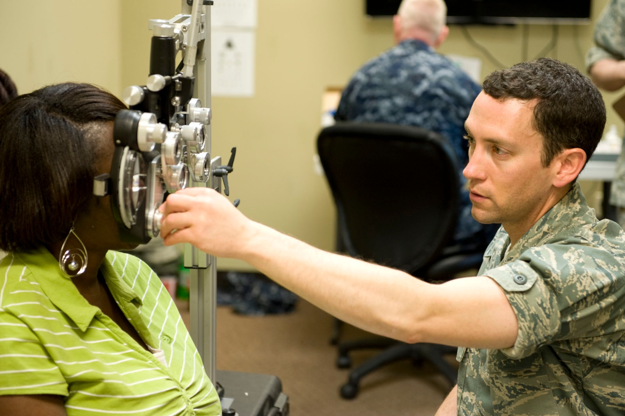 HAYNEVILLE, Ala. - Capt. Andrew Adamich, an optometrist from the 176th Medical Group, Alaska Air National Guard, performs a sight test with a phoropter on a patient to determine her eyeglass prescription, May 3, 2011.  Adamich and about 35 other members from the 176th Wing are in Alabama for an Innovative Readiness Training (IRT) mission. The IRT program allows for real-world training opportunities for military personnel while providing needed services to under-served communities in the United States.  Alaska Air National Guard photo by Master Sgt. Shannon Oleson.