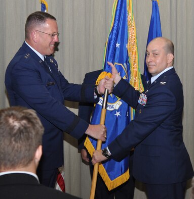 Col. Mustafa "Kujo" Koprucu, right, accepts the 505th Command and Control Wing guidon, symbolizing his assumption of command, from U.S. Air Force Warfare Center Commander Maj. Gen. James Hyatt, during a change of command ceremony here May 3. The wing's former vice commander, Colonel Koprucu replaces Col. Edward McKinzie who is slated to become executive officer for U.S. Army Gen. Carter F. Ham at U.S. Africa Command. (U.S. Air Force photo/Keith Keel)