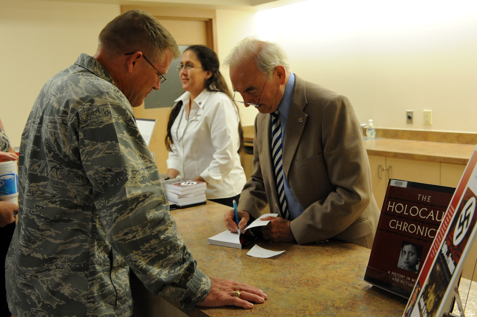 Joseph Callewaert, author of ?Lights Out for Freedom?, signs copies of his novel during the Holocaust remembrance ceremony, Hurlburt Field, Fla., May 5, 2011. The book is Mr. Callewaert?s journal and a chronicle of the Nazi occupation of Belgium. (U.S. Air Force photo by Airman 1st Class Caitlin O?Neil-McKeown/RELEASED)
  
