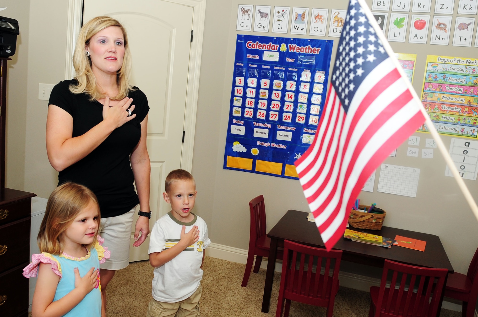 Mrs. Hilary Free says the Pledge of Allegience with her children, Ashlin, 4, and Will, 5, prior to beginning their school day at their home in Shreveport, La., April 29. Mrs. Free home schools all three of her children including her one year-old daughter, Presley. (U.S. Air Force photo/Senior Airman Joanna M. Kresge)