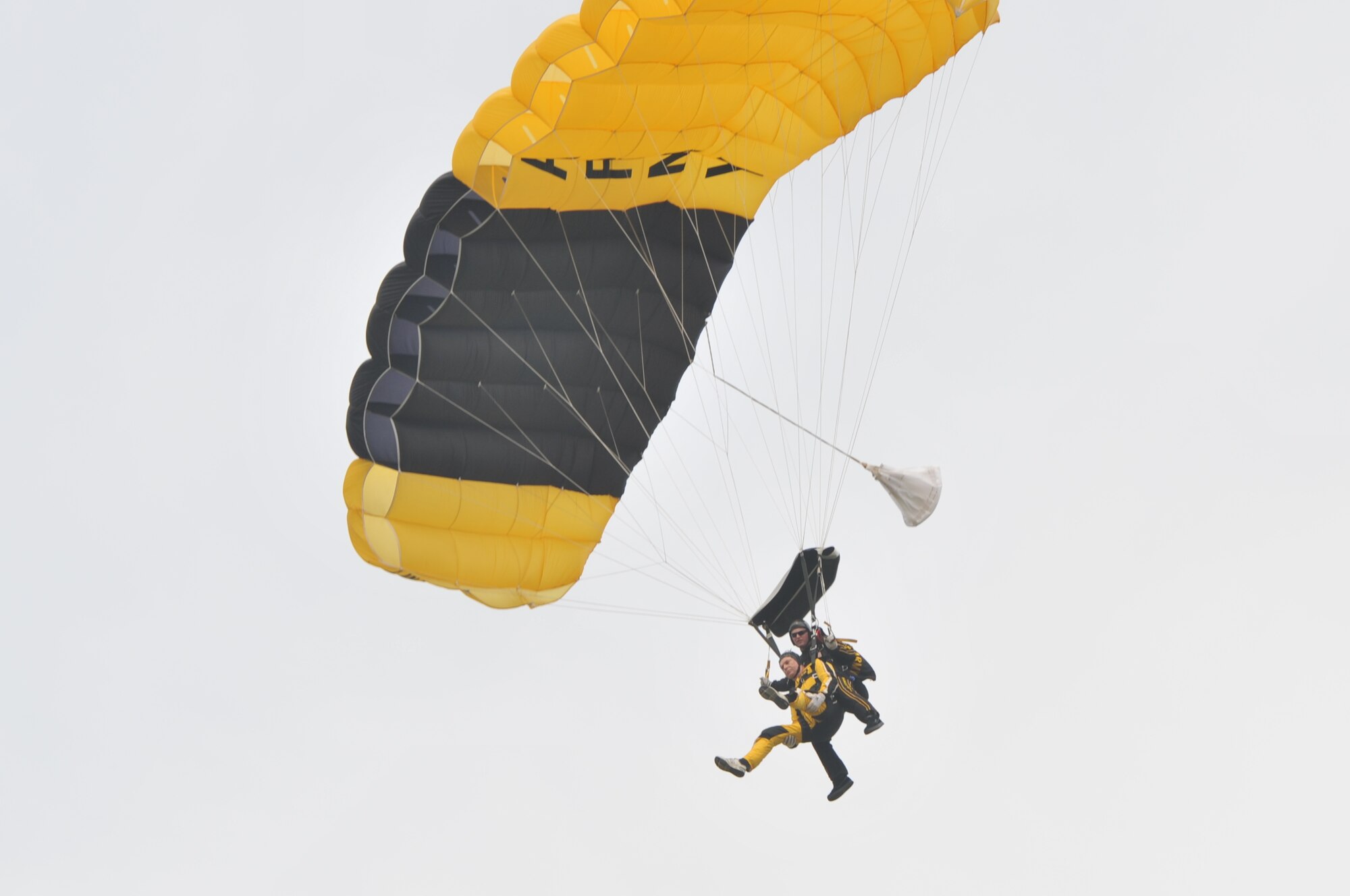 A U.S. Army Golden Knight prepares to touch down with a community leader during an aerial demonstration tandem jump at Joint Base McGuire-Dix-Lakehurst Tuesday.  This is the second consecutive year the Golden Knights have performed at the joint base. This year they are joied by the U.S. Army Marksmanship Unit. The event was held to highlight the warfighter and educate the local community on the capabilities of America’s military. (U.S. Air Force photo by Wayne Russell/Released)
