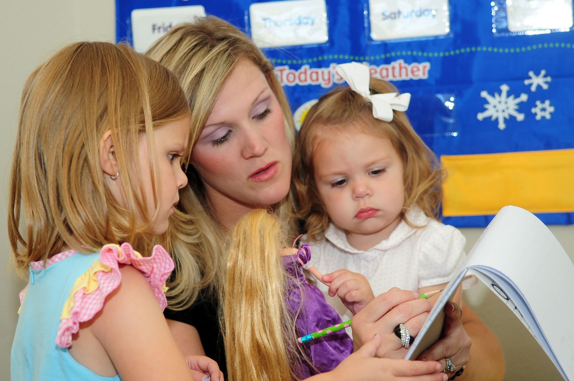 Mrs. Hilary Free helps her daughter, Ashlin, 4, draw a lower-case “f” while holding her one year-old daughter, Presley, during class at their home in Shreveport, La., April 29. Mrs. Free is the wife of Maj. William Free, Eighth Air Force B-2 Spirit evaluator. (U.S. Air Force photo/Senior Airman Joanna M. Kresge)