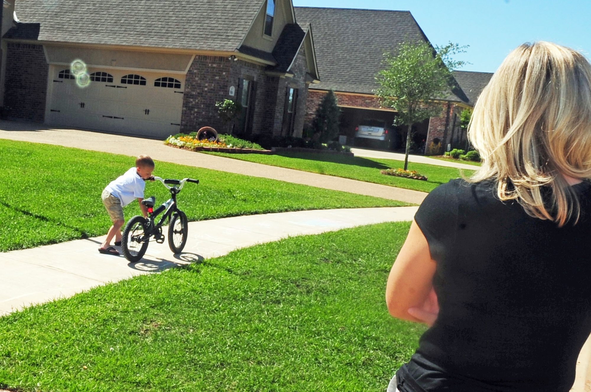 Mrs. Hilary Free, mother of three, watches her son, Will, 5, play with his bicycle outside their home in Shreveport, La., April 29. Mrs. Free stays home with her three children who help her with household chores, attend home school classes, assist with bible studies and other church activities and spend quality time playing outdoors together. (U.S. Air Force photo/Senior Airman Joanna M. Kresge) 