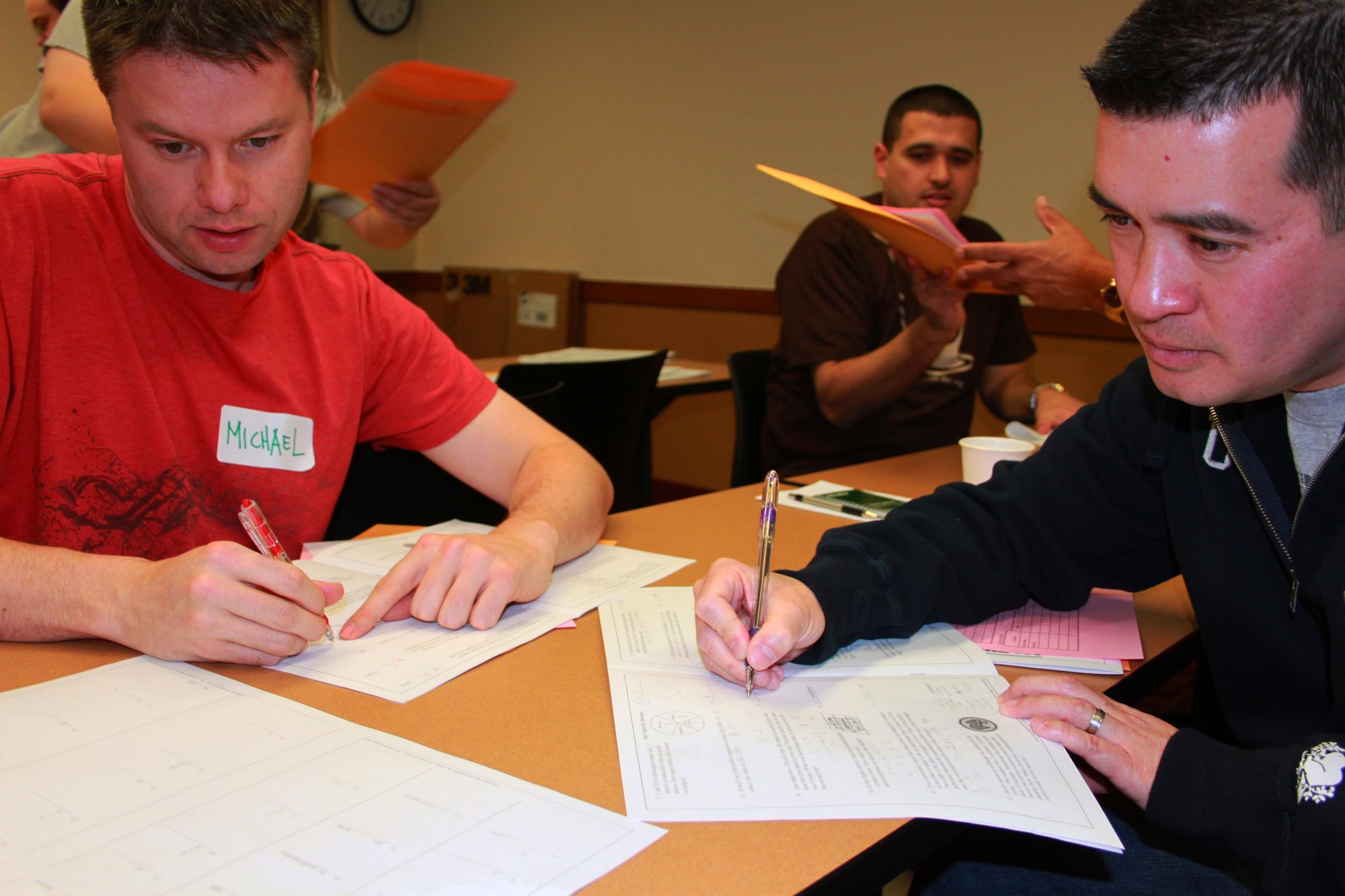 Maj. Michael Knight, left, Staff Sgt. Giovanni Carotti, back, and Capt. Dominic Wong, right, grade tests during the state MATHCOUNTS competition at Denver University in Denver on March 12. Members of 7 SOPS also volunteered for regional competitions in priors weeks. (U.S. Air Force photo by Tech. Sgt. Scott P. Farley)