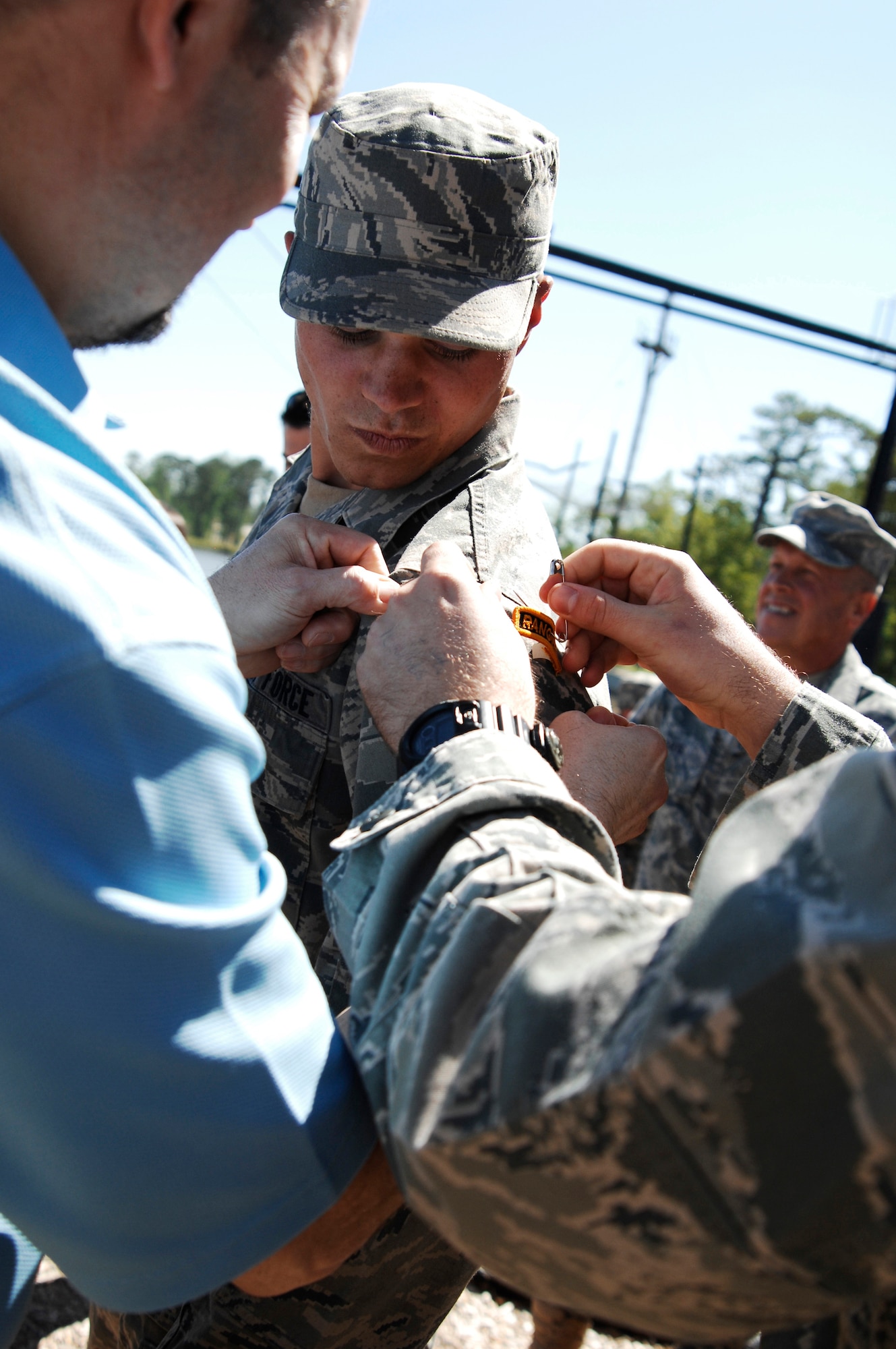 FORT BENNING, Ga.-- Airman 1st Class Matthew Garner, 823rd Base Defense Squadron member, has his Ranger tab pinned on by his father, Don Garner, and mentor, Staff Sgt. Seth Hunter, after completing the intense61-day U.S. Army Ranger School April 29. He was the only Airman to make it through the course for this class and is one of less than 300 to make it since the school opened in the 1950s. (U.S. Air Force photo/Airman 1st Class Brigitte N. Brantley-Sisk)(RELEASED) 
